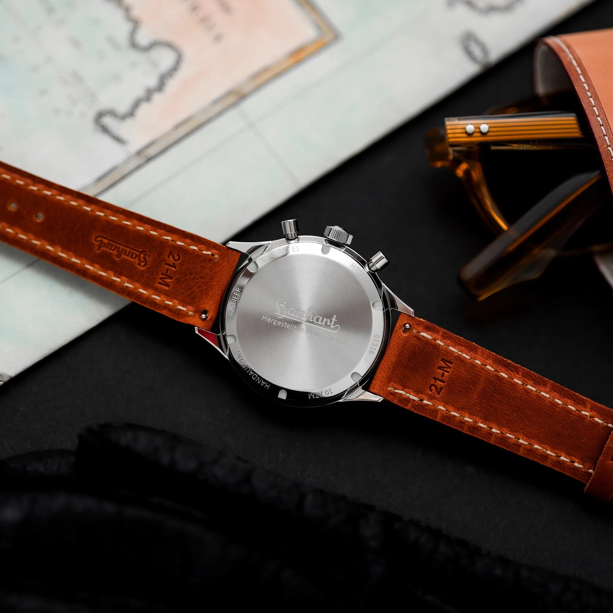 Produktfotografie des Hanhart 417 ES "Moby Dick" Chronographs mit 42mm-Gehäuse und weißem Zifferblatt am hellbraunen Lederband zeigt den verschraubten Gehäuseboden