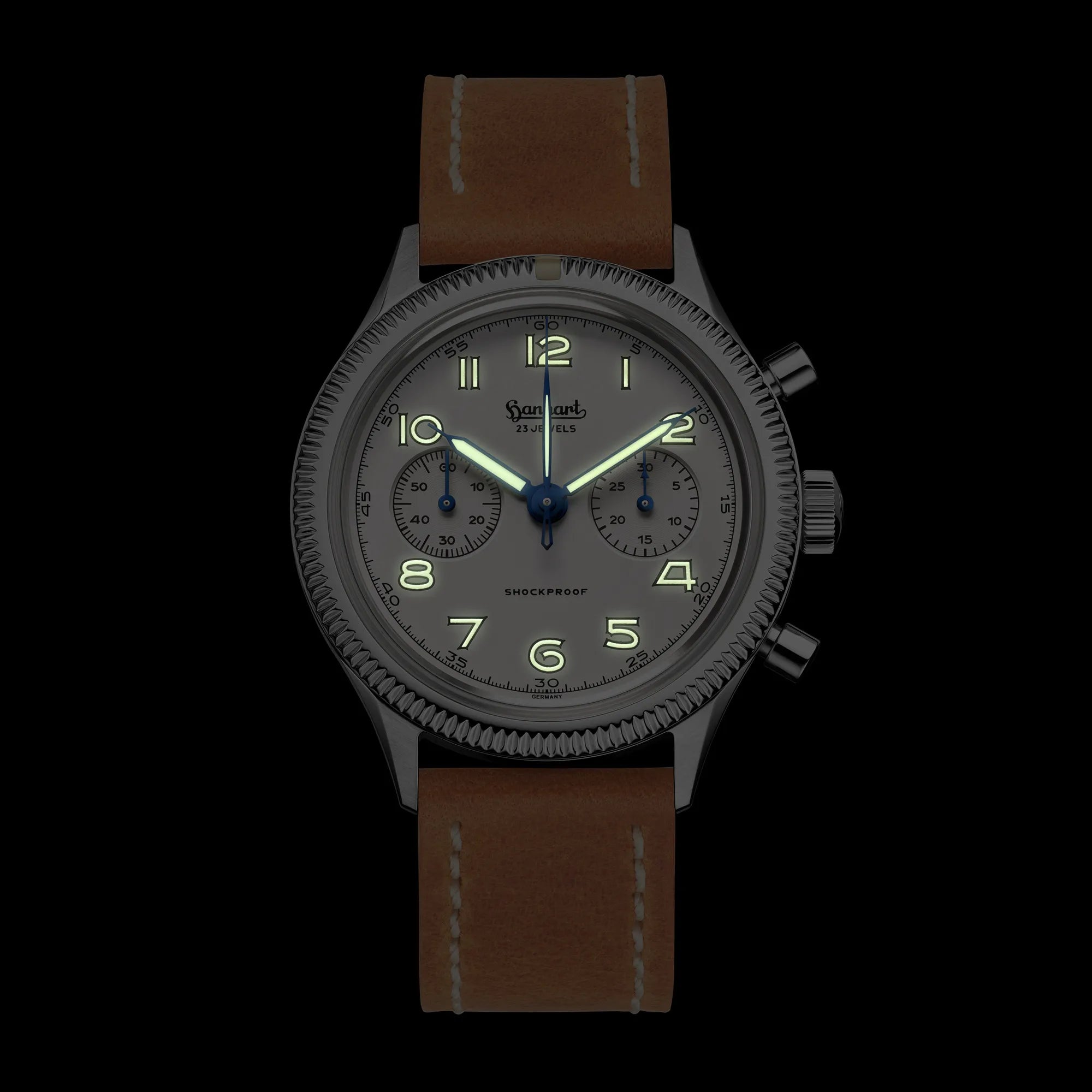 Hanhart 417 ES "Moby Dick" Chronographs mit 42mm-Gehäuse und weißem Zifferblatt am hellbraunen Lederband bei Nacht mit Leuchtmasse in Zeiger und Ziffer