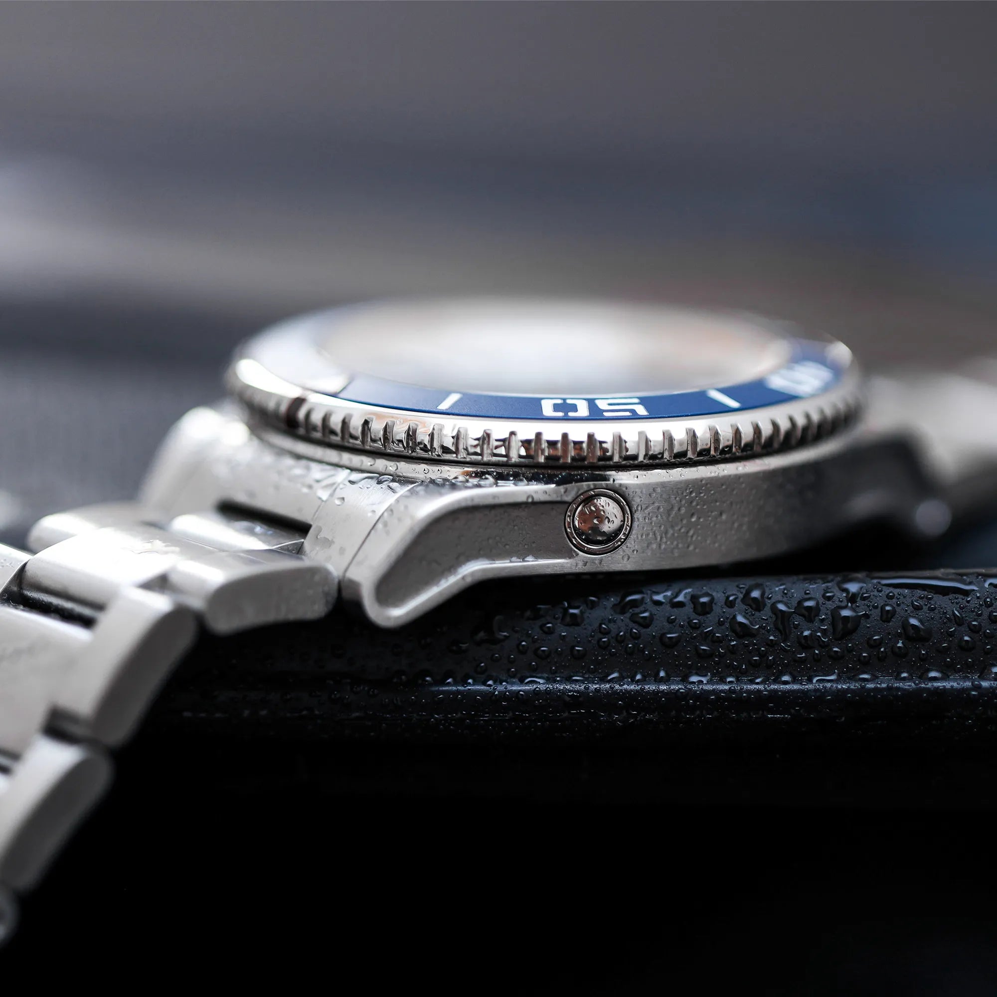 Produktfotografie der Hanhart Aquasphere mit dem blau-schwarz verlaufenden "Ocean Fade"-Zifferblatt und blauem  Keramik-Inlay auf der Lünette am Edelstahlarmband