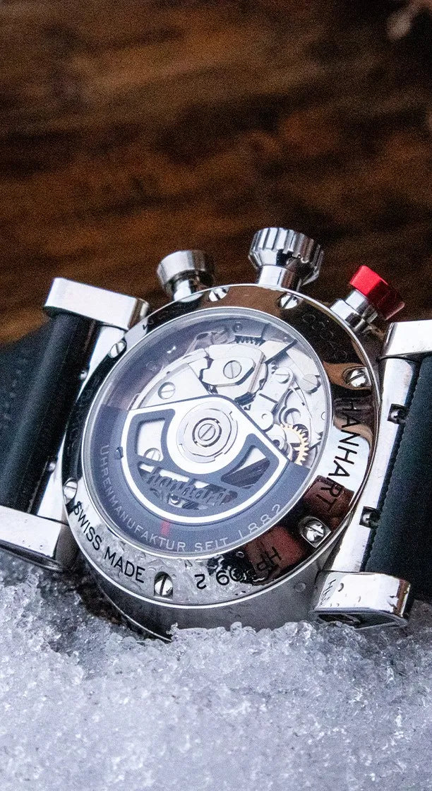 Produktfotografie des Hanhart Pioneer TachyTele Chronographen mit altweißem Zifferblatt und rot gehaltener Tachymeter-Skala und Telemeter-Skala am braunen Kalbslederband mit Niete