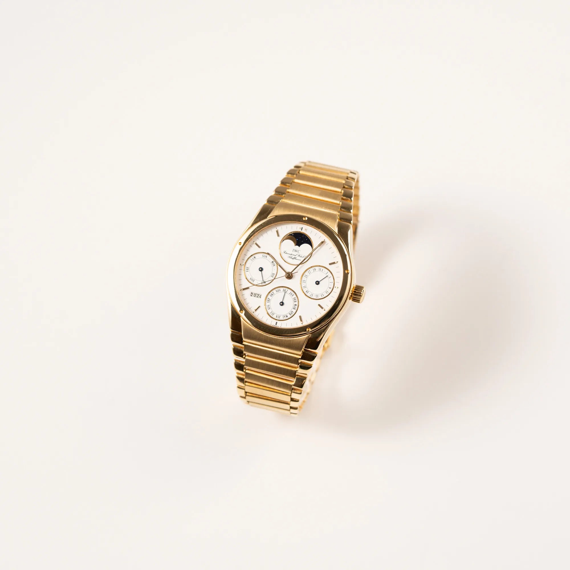 Leicht schräge Ansicht der IWC Ingenieur Perpetual Calendar in Gelbgold mit weißem Zifferblatt und zughörigem Gelbgold-Armband