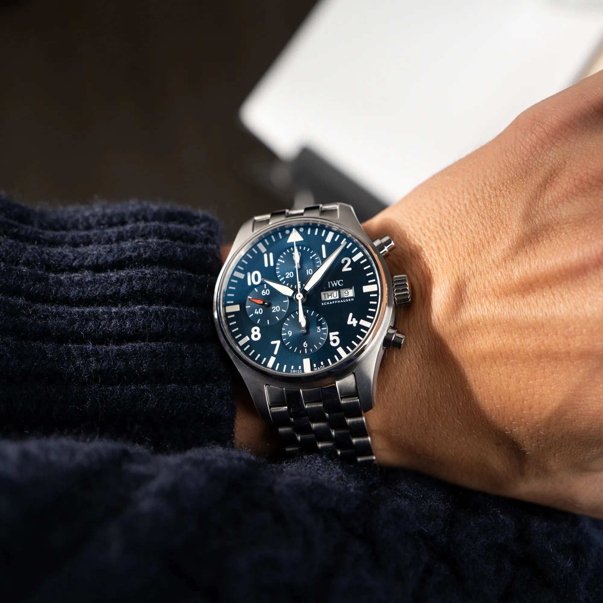 Mann trägt den IWC Pilot Chronograph "Le Petit Prince" IW377717 mit 43 mm Gehäuse und blauem Zifferblatt am Edelstahl-Armband an seinem Handgelenk