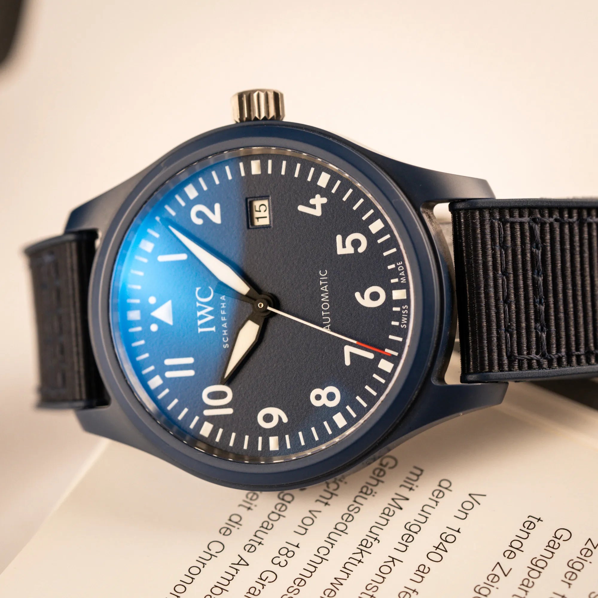 Produktfotografie der limitierten IWC Pilot's Watch IW328101 "Laureus Sport for Good" mit blauem Keramik-Gehäuse  mit Lichtspiegelung im Uhrenglas