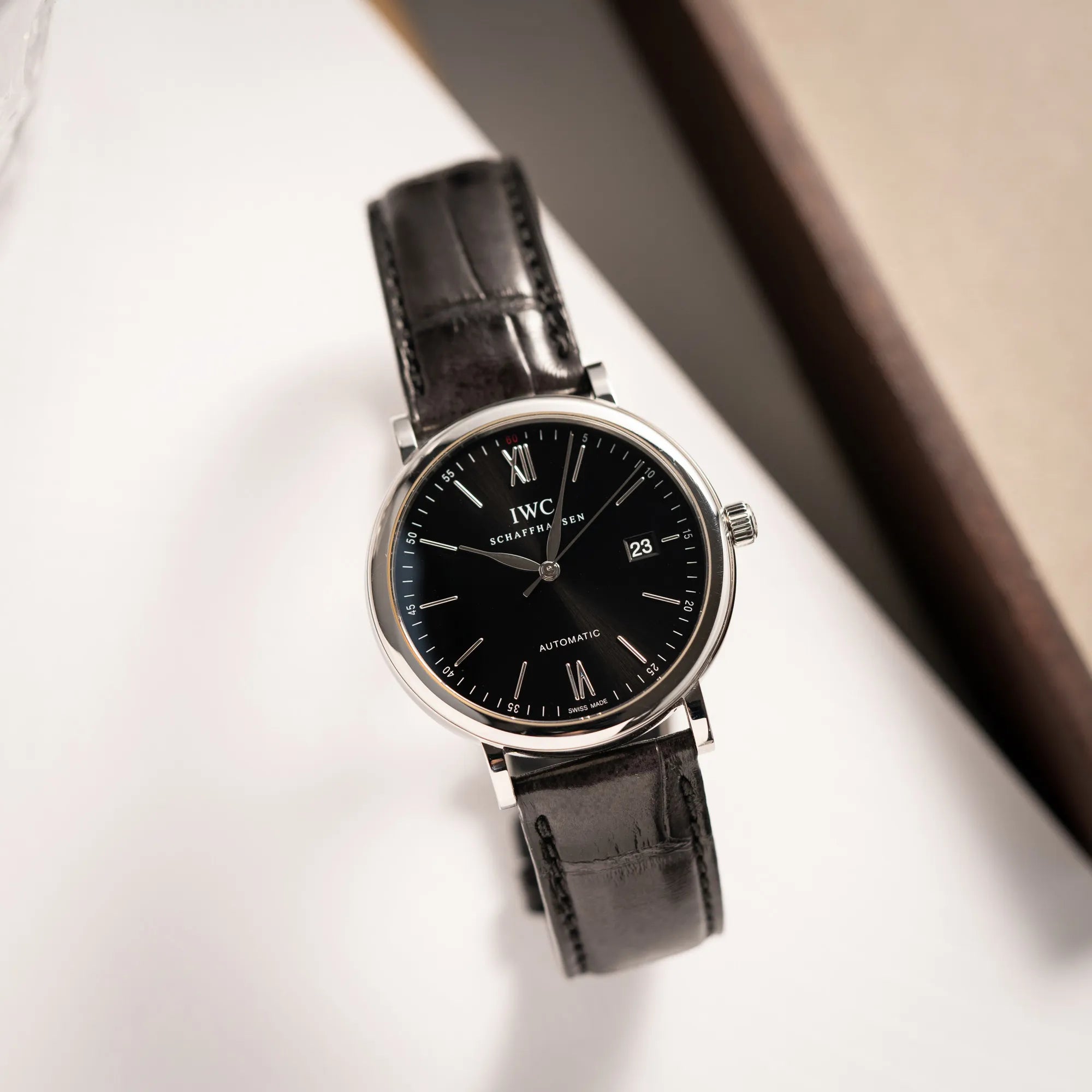 Foto aus der Vogelperspektive der IWC Portofino 40 Automatik Armbanduhr mit schwarzem Zifferblatt am schwarzen Lederband