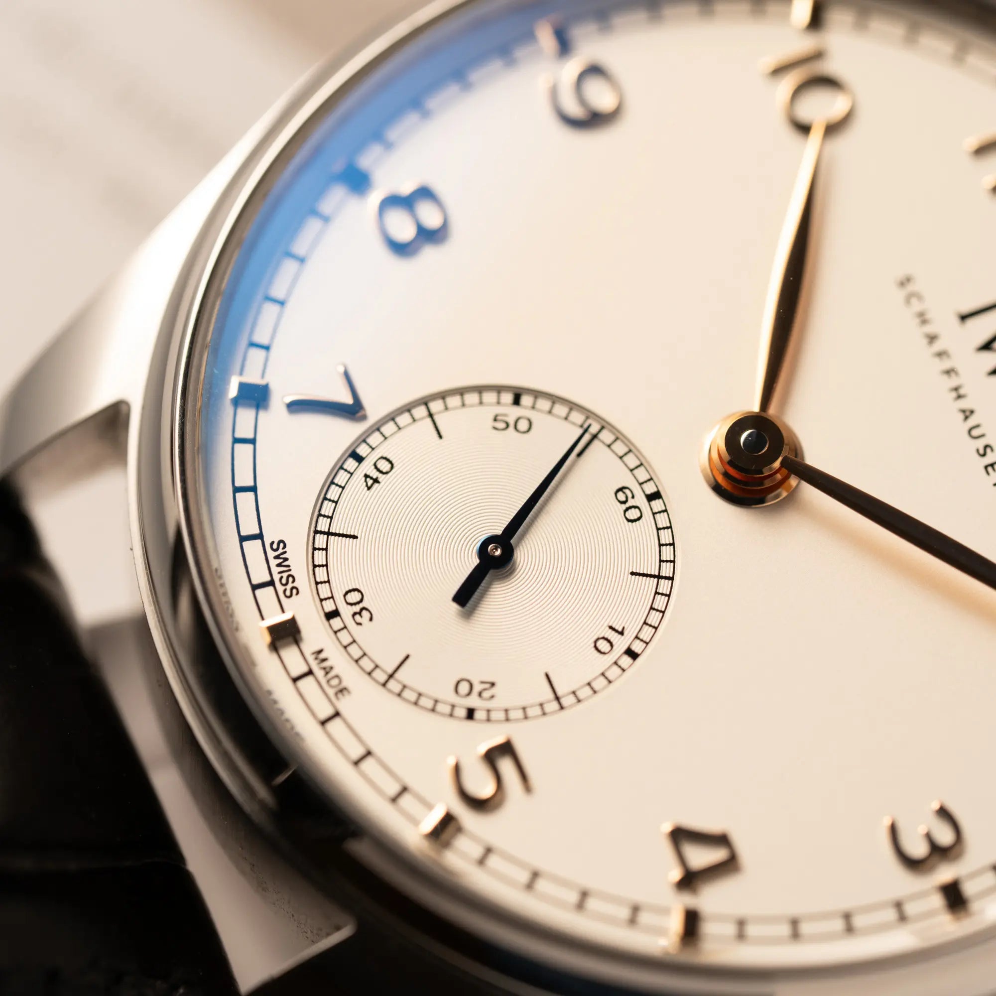 Detailaufnahme der kleinen Sekunde auf 6 Uhr von der IWC Portugieser 40 Automatik IW358303 mit weißem Zifferblatt und roségoldenen Zeiger- und Index-Details am schwarzen Lederband