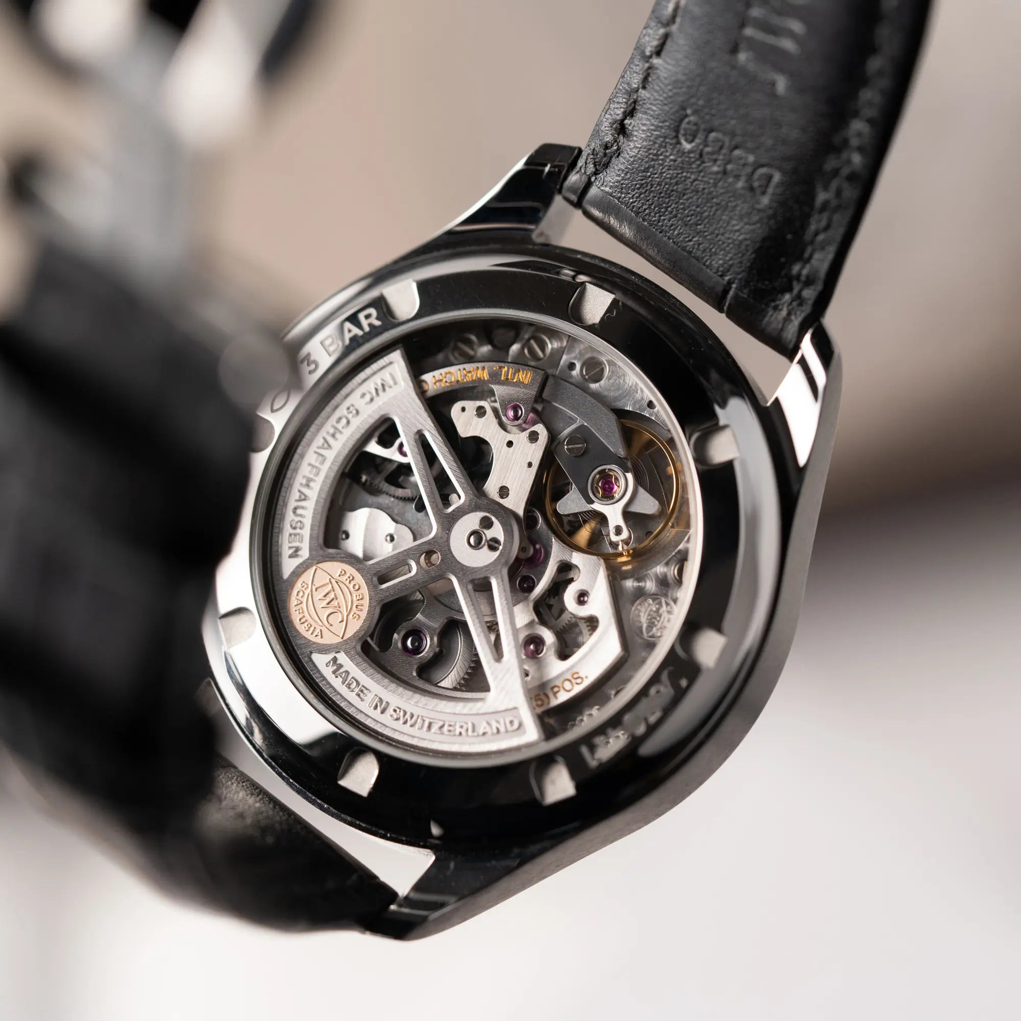 Gehäuseboden mit Sichtglas mit Blick auf das Cal 82200 von der IWC Portugieser 40 Automatik IW358303 mit weißem Zifferblatt und roségoldenen Zeiger- und Index-Details am schwarzen Lederband