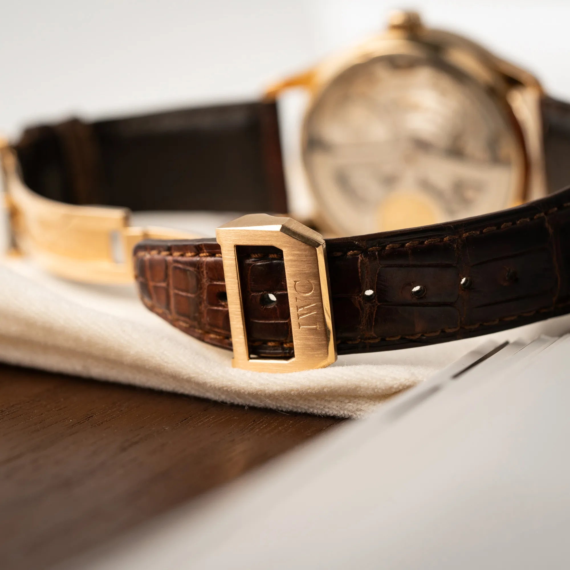 Detailaufnahme der Schliesse mit IWC Logo des Portugieser Ewiger Kalender IW502213 von IWC in einem 42mm-Rosegold-Gehäuse am braunem IWC Lederband mit einem sanften weißem Zifferblatt