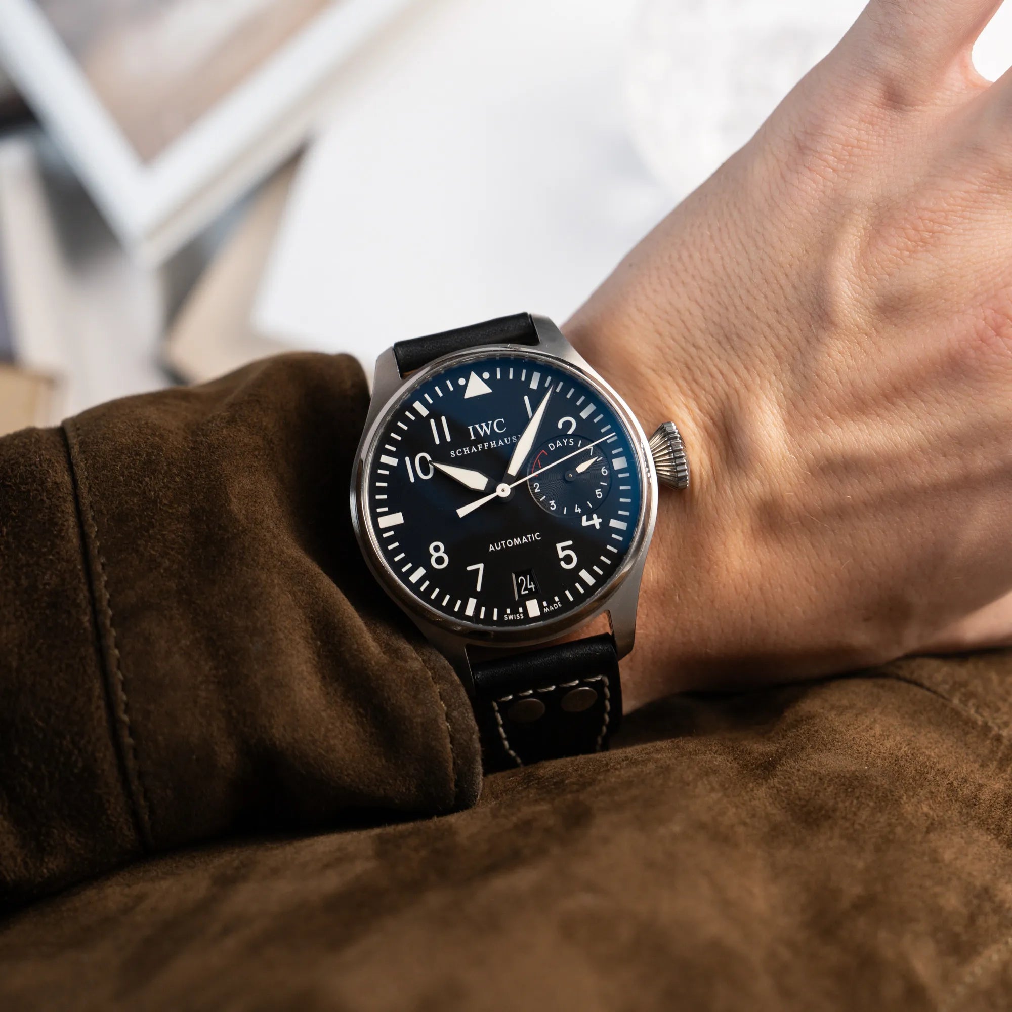 Mann trägt die IWC Big Pilot 46 Armbanduhr der Referenz IW500401 mit schwarzem Zifferblatt und der Power-Reserve-Anzeige bei 3 Uhr