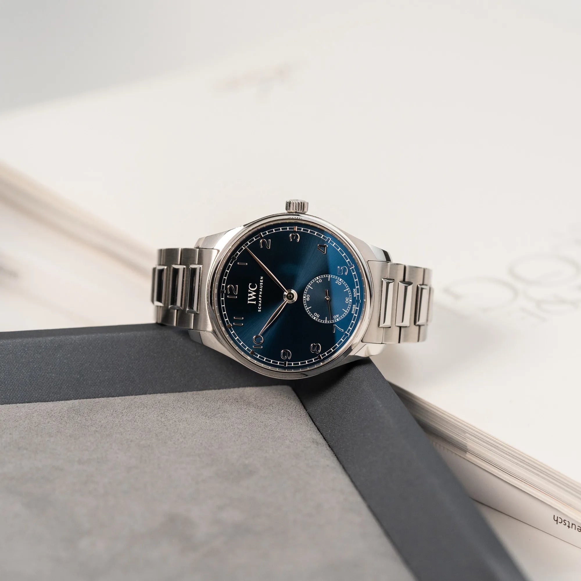 Produktfotografie der IWC Armbanduhr Portugieser 40 Automatic mit blauem Zifferblatt am IWC-Edelstahlband (seitlich liegend)