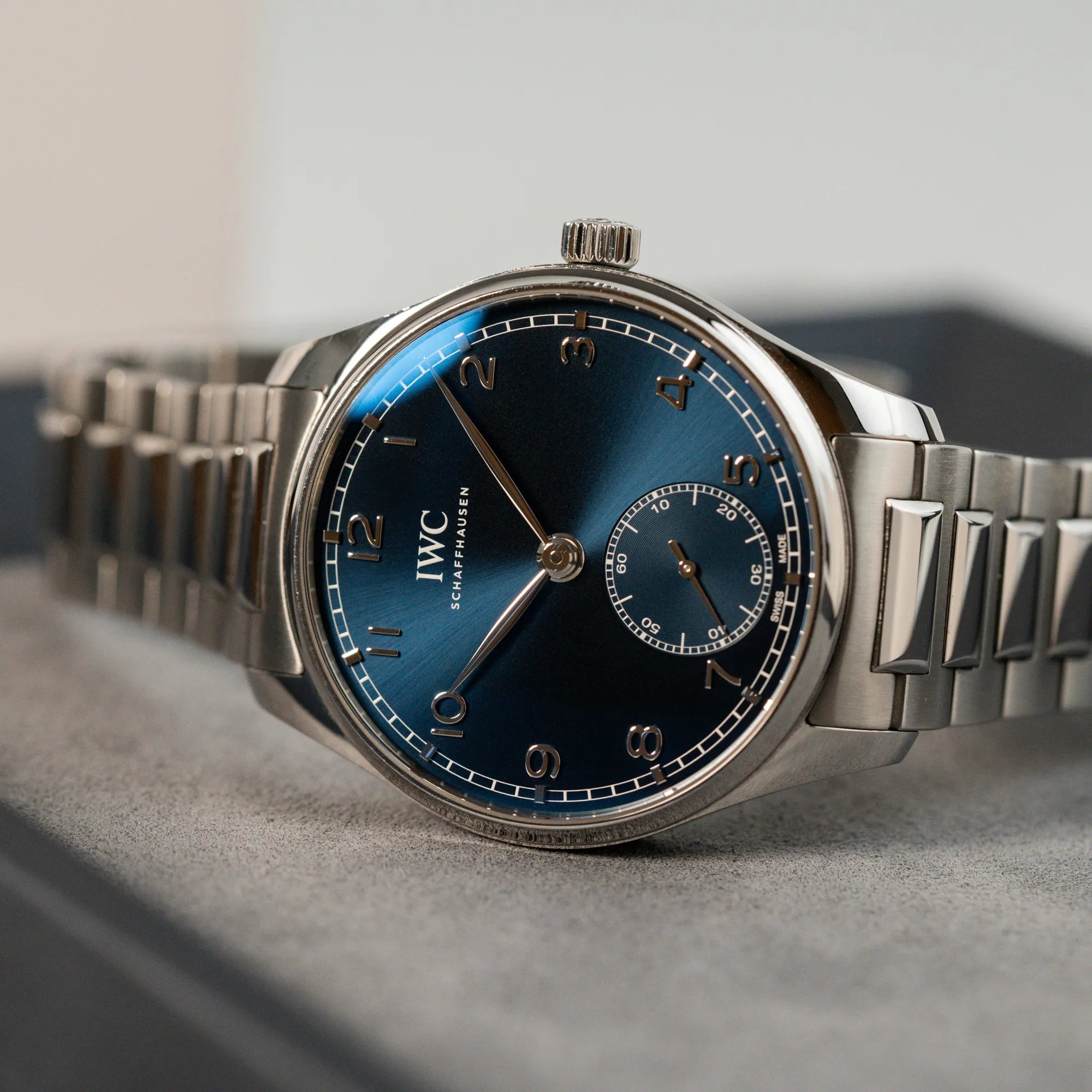 Produktfotografie der IWC Armbanduhr Portugieser 40 Automatic mit blauem Zifferblatt am IWC-Edelstahlband auf einem grauen Juweliers-Tablett