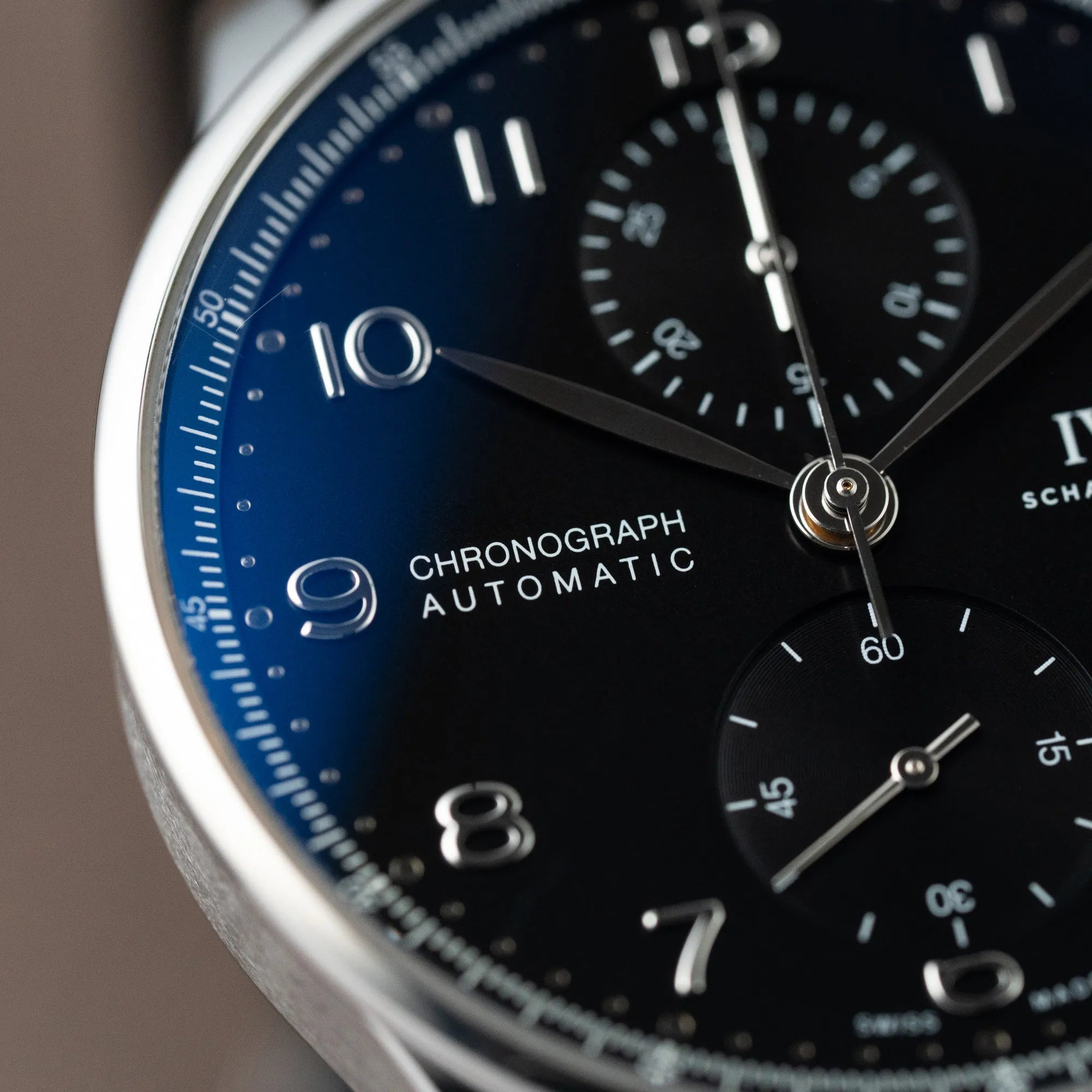 Detailaufnahme des Zifferblatts der IWC Portugieser Chronograph Uhr mit schwarzem Zifferblatt an einem schwarzen Lederband