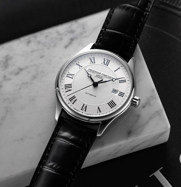 Produktfotografie der Frederique Constant Classics Automatic FC-303MC5B6 mit silberfarbenen Zifferblatt und römischen Indizes am schwarzen Lederband