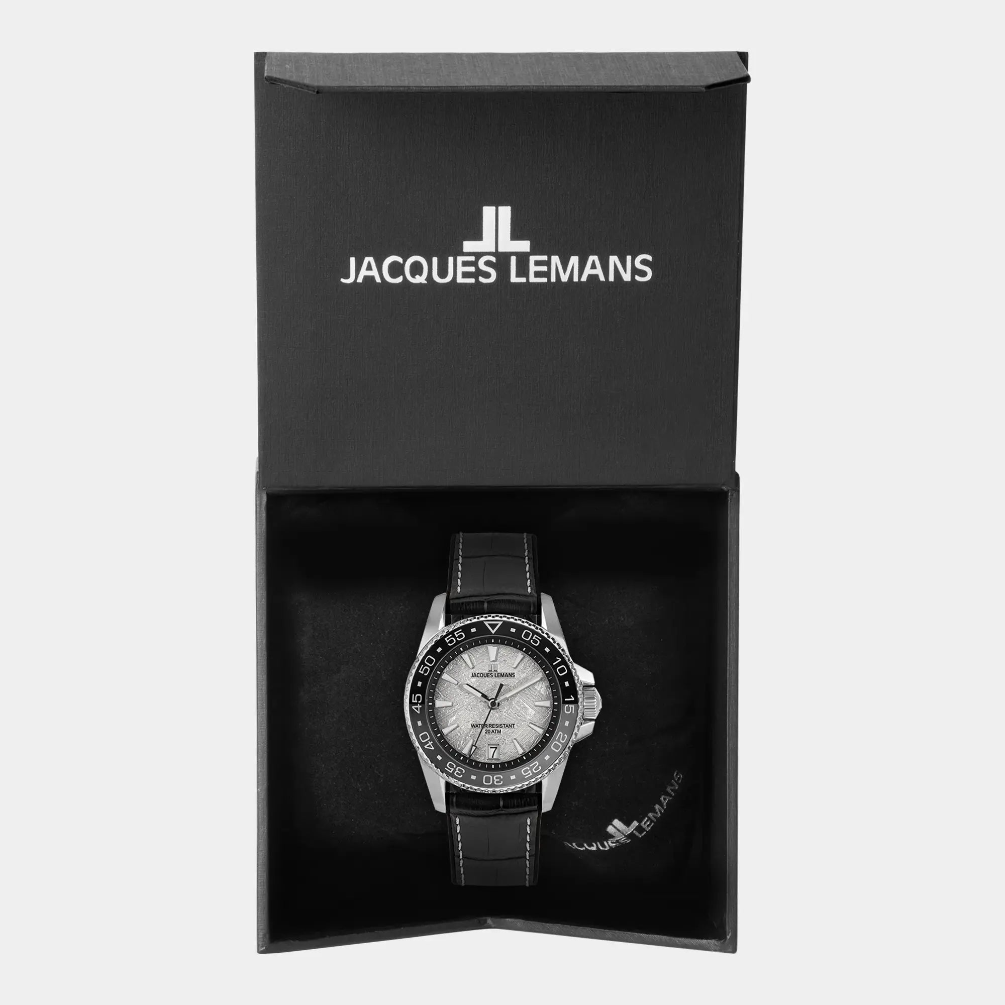 Jacques Lemans Liverpool 1-2205E Taucher-Armbanduhr am schwarzen Lederband mit schwarz-grauer Lünette und einem Zifferblatt im Meteorit-Look liegt in der zugehörigen Uhrenbox