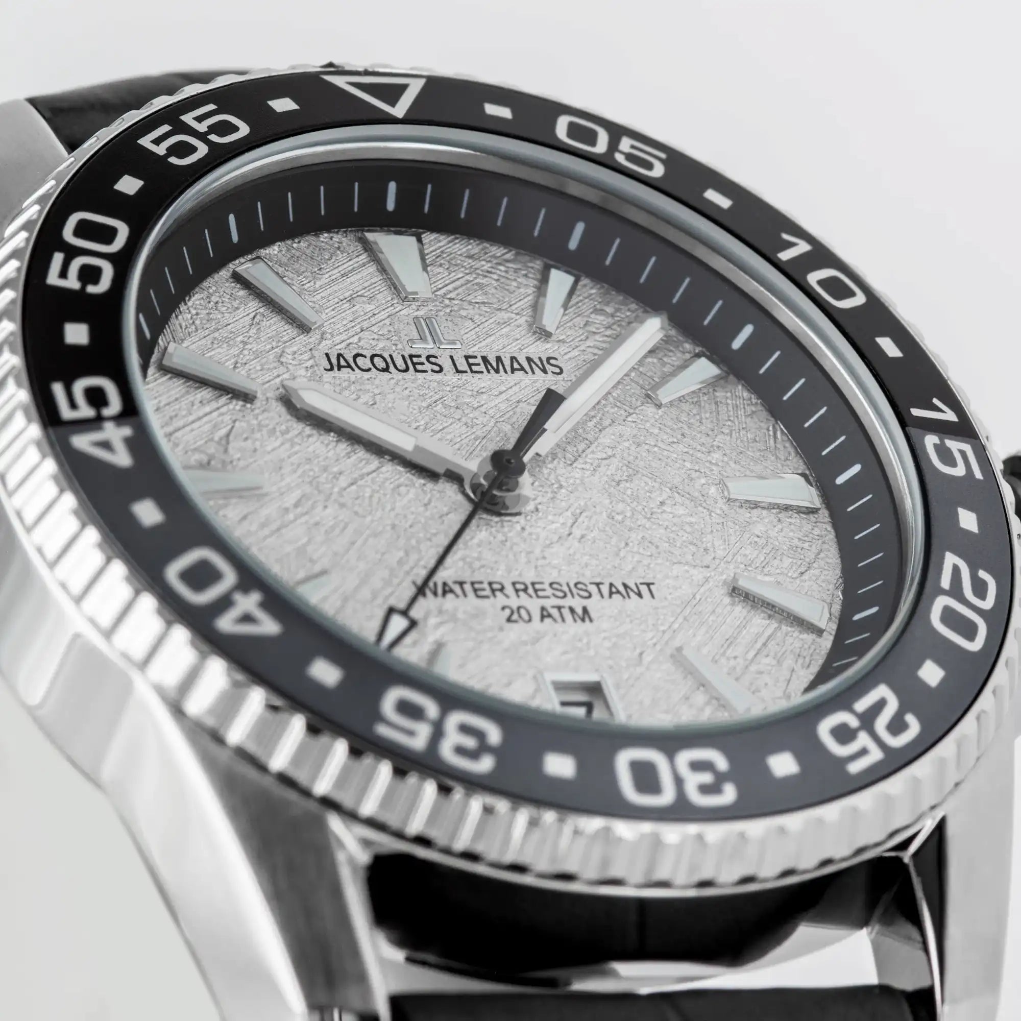 Detailaufnahme der Jacques Lemans Liverpool 1-2205E Taucher-Armbanduhr am schwarzen Lederband mit schwarz-grauer Lünette und einem Zifferblatt im Meteorit-Look