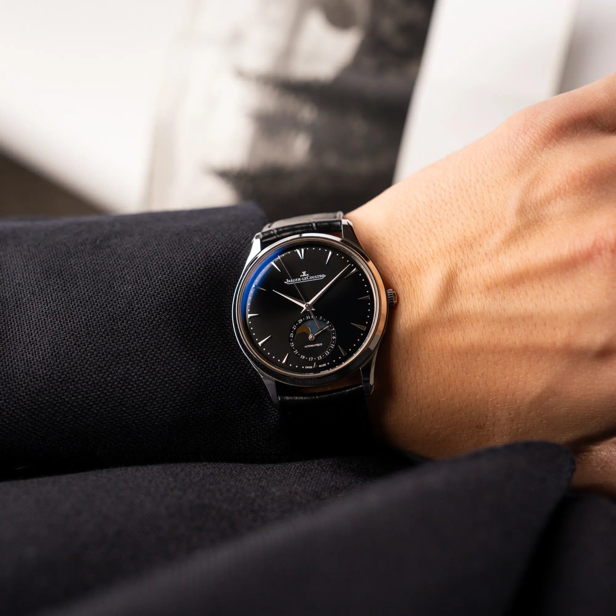 Mann trägt die Jaeger-LeCoultre Master Control Q1368470 mit Datum und Mondphase in der schwarzen Zifferblattvariante für einen Wristshot