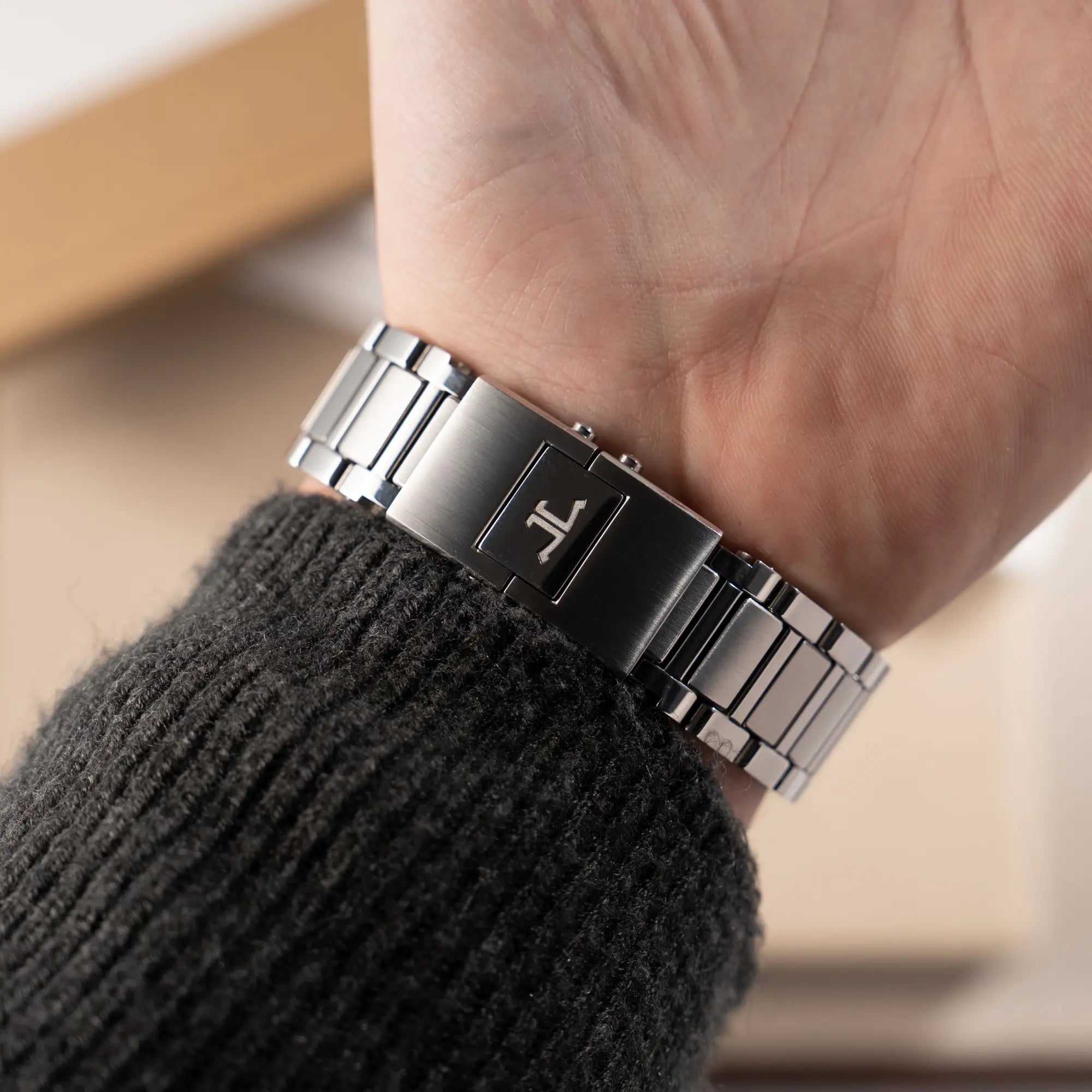 Mann trägt den Jaeger-LeCoultre Polaris Chronograph aus 2022 mit  blauem Zifferblatt in einem 42mm Gehäuse am Stahlband an seinem Handgelenk und präsentiert die originale JLC-Schliesse in die Kamera