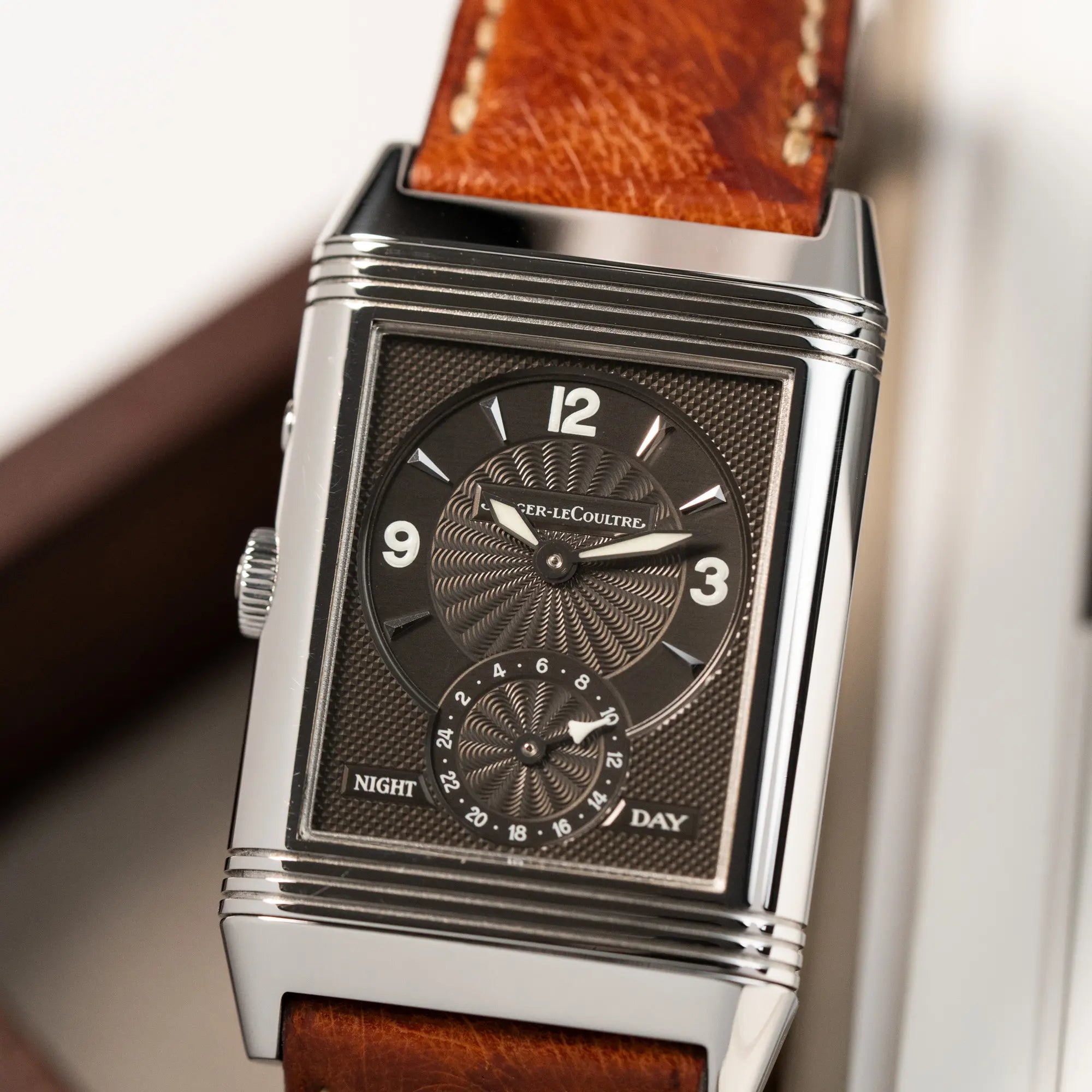 Detailaufnahme der JLC Reverso Duoface 270.8.54 am braunen Lederband mit dem Night-and-Day-Zifferblatt nach vorne zeigend