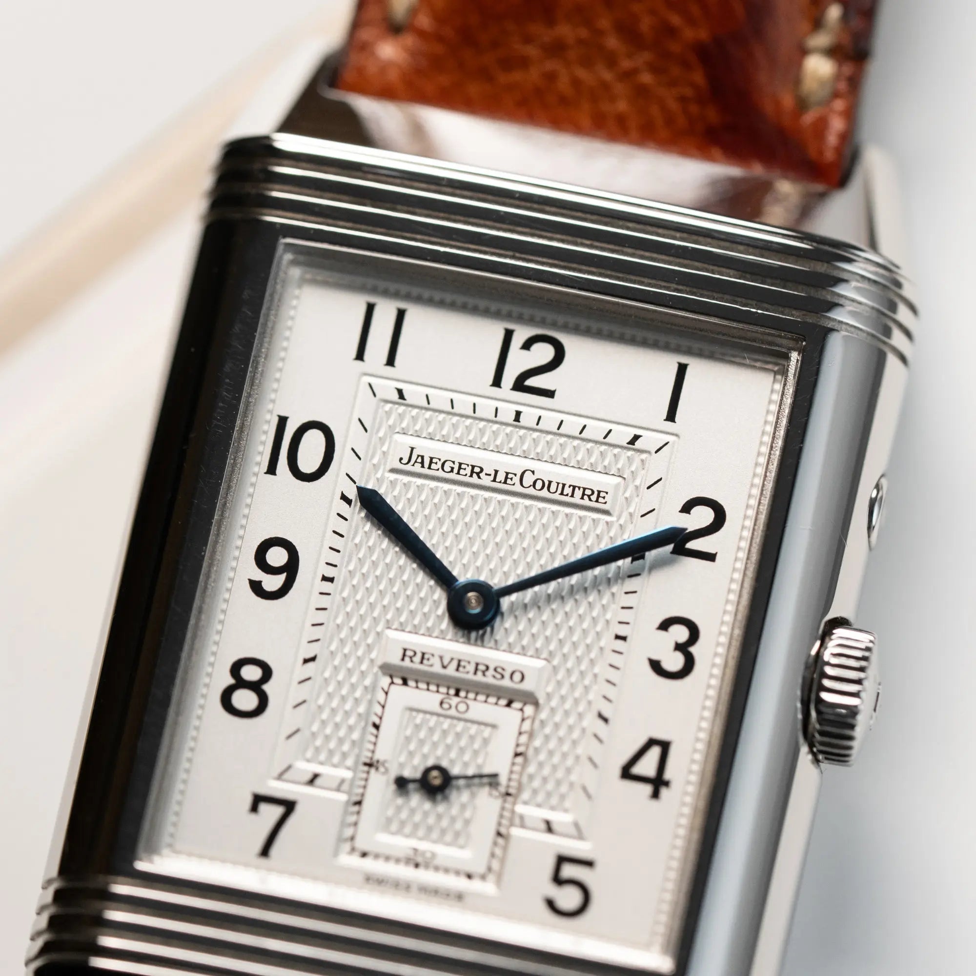 Detailaufnahme der JLC Reverso Duoface 270.8.54 am braunen Lederband mit Fokus auf dem Jaeger-LeCoultre Schriftzug