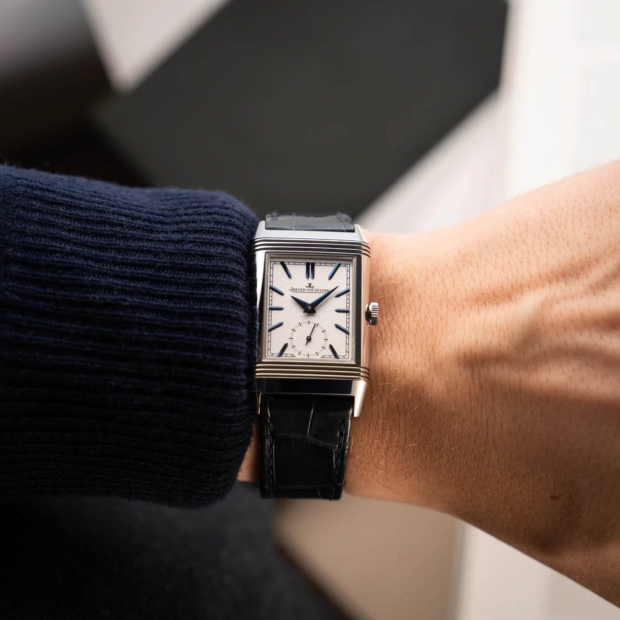 Mann trägt die Jaeger-LeCoultre Reverso Tribute Duoface Q3908420 an seinem Handgelenk und zeigt das weiße Zifferblatt mit kleiner Sekunde in die Kamera