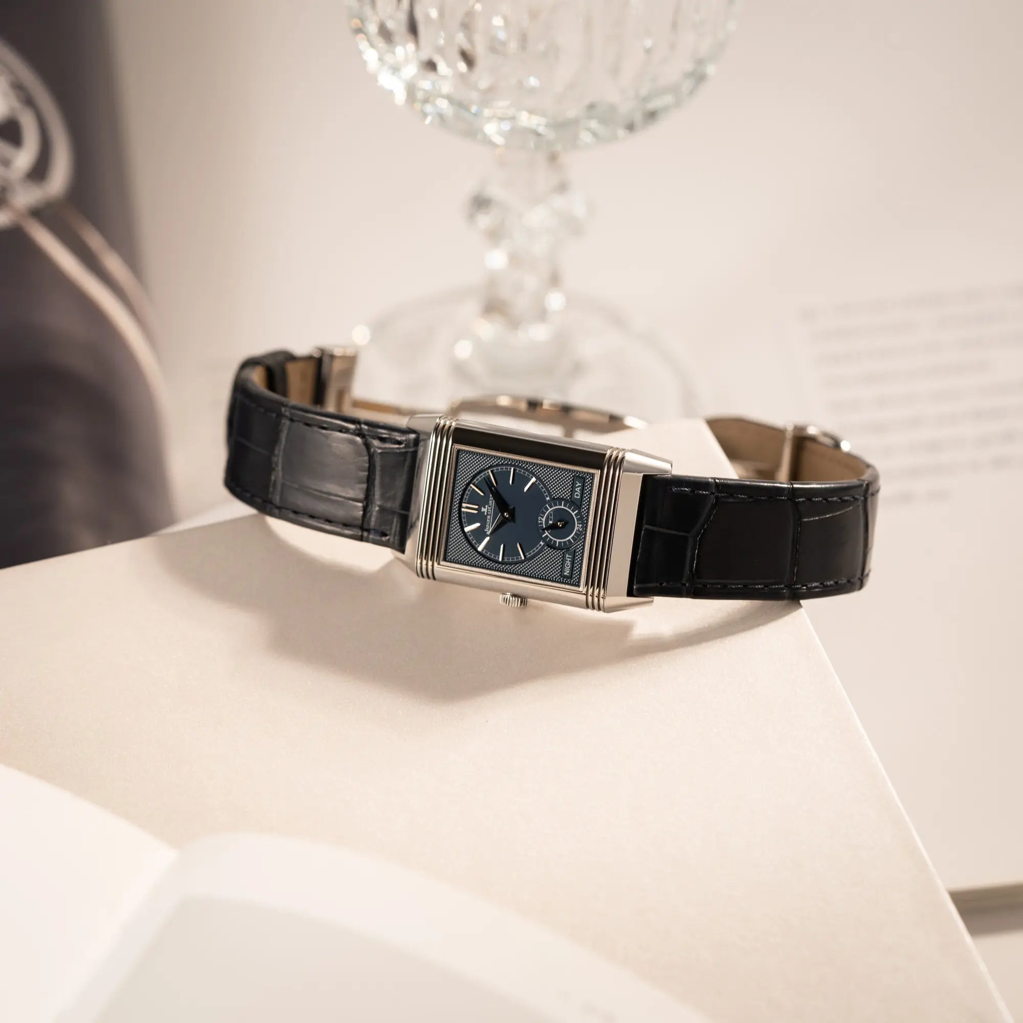 Produktfotografie der Jaeger-LeCoultre Reverso Tribute Duoface Q3908420 an einem dunkelblauen Lederband zeigt das blaue Day and Night Zifferblatt