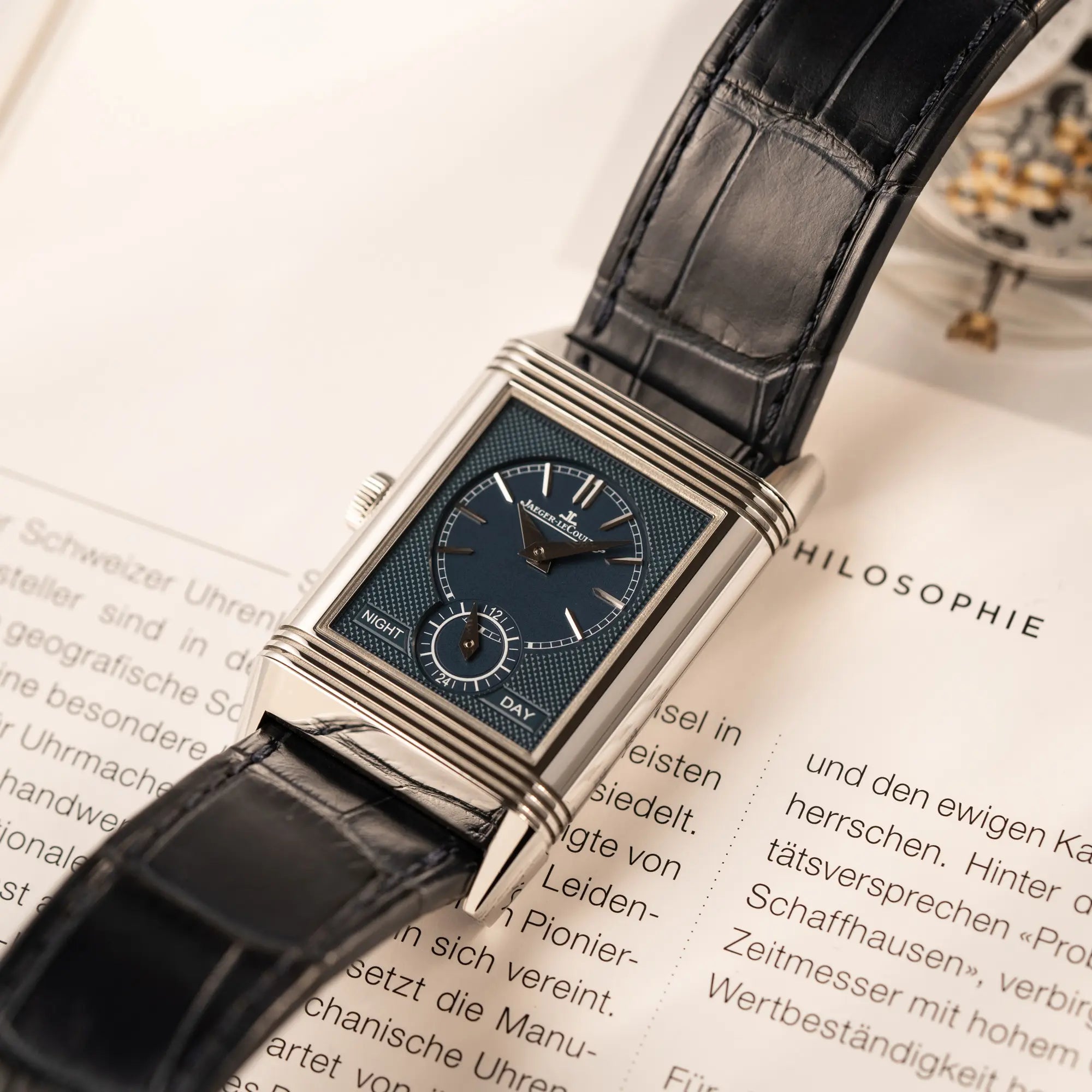 Produktfotografie als Titelbild für die Jaeger-LeCoultre Reverso Tribute Duoface Q3908420 zeigt das blaue Day-and-Night Zifferblatt und den betätigten Reverso-Mechanismus
