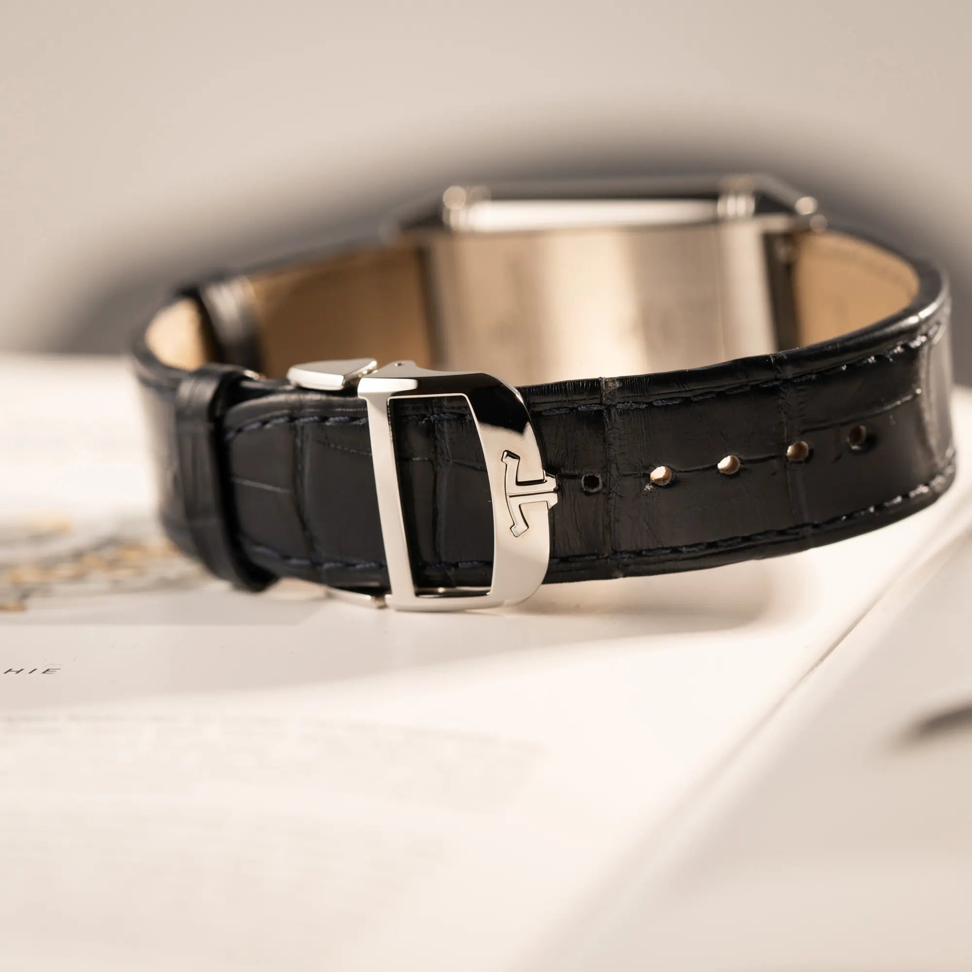 Produktfotografie der Jaeger-LeCoultre Reverso Tribute Duoface Q3908420 an einem dunkelblauen Lederband zeigt die geschlossene Faltschliesse im Detail