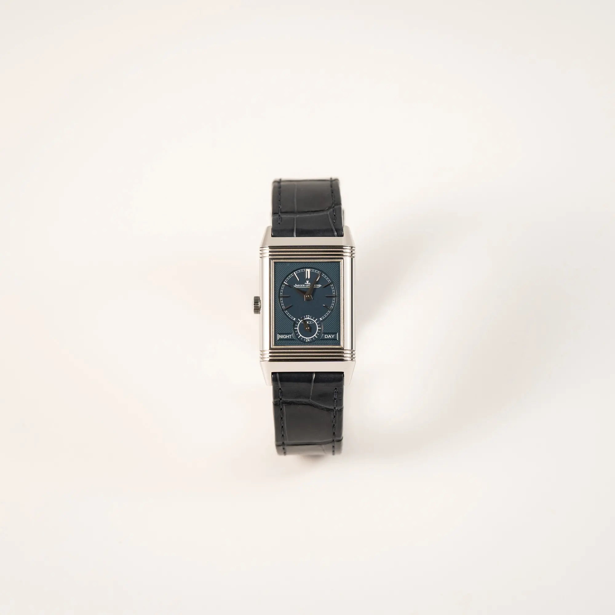 Frontale Ansicht der Jaeger-LeCoultre Reverso Tribute Duoface Q3908420 mit dunkelblauem Day&Night-Zifferblatt an einem dunkelblauen Lederband