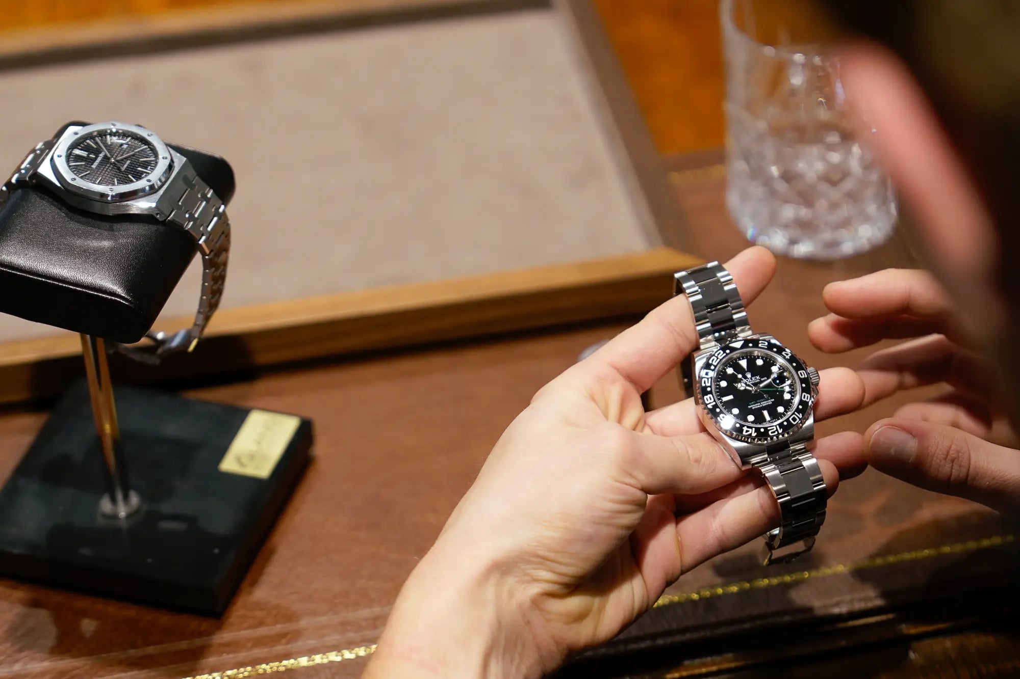 Kunde begutachtet eine Rolex GMT-Master II mit der schwarzen Keramik-Lünette  im Ladengeschäft von Schmuckatelier Lang