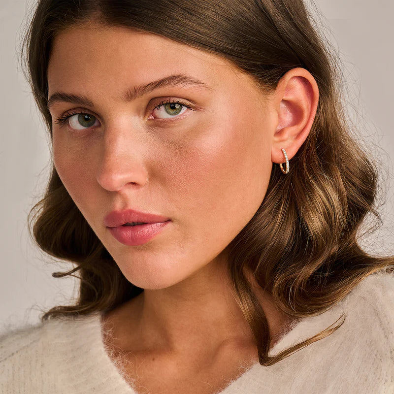 Model trägt Ohrringe von Blush Jewels Damenring aus 14 karätigem Gelbgold mit feinen Labor-Diamanten auf der Schiene