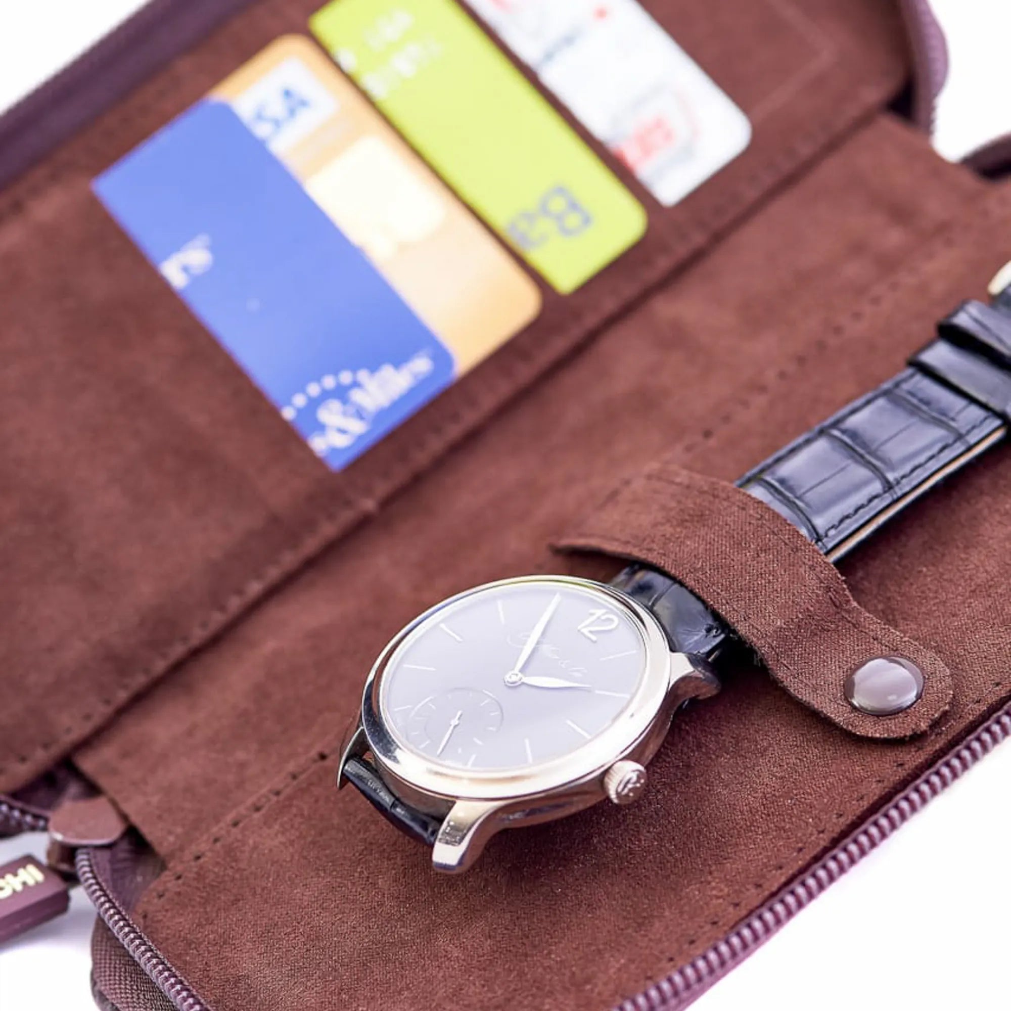 Etuis für Schreibgeräte oder Uhren in schokobraunem Leder von Leanschi gefüllt mit Karten und einer Uhr von Moser & Cie