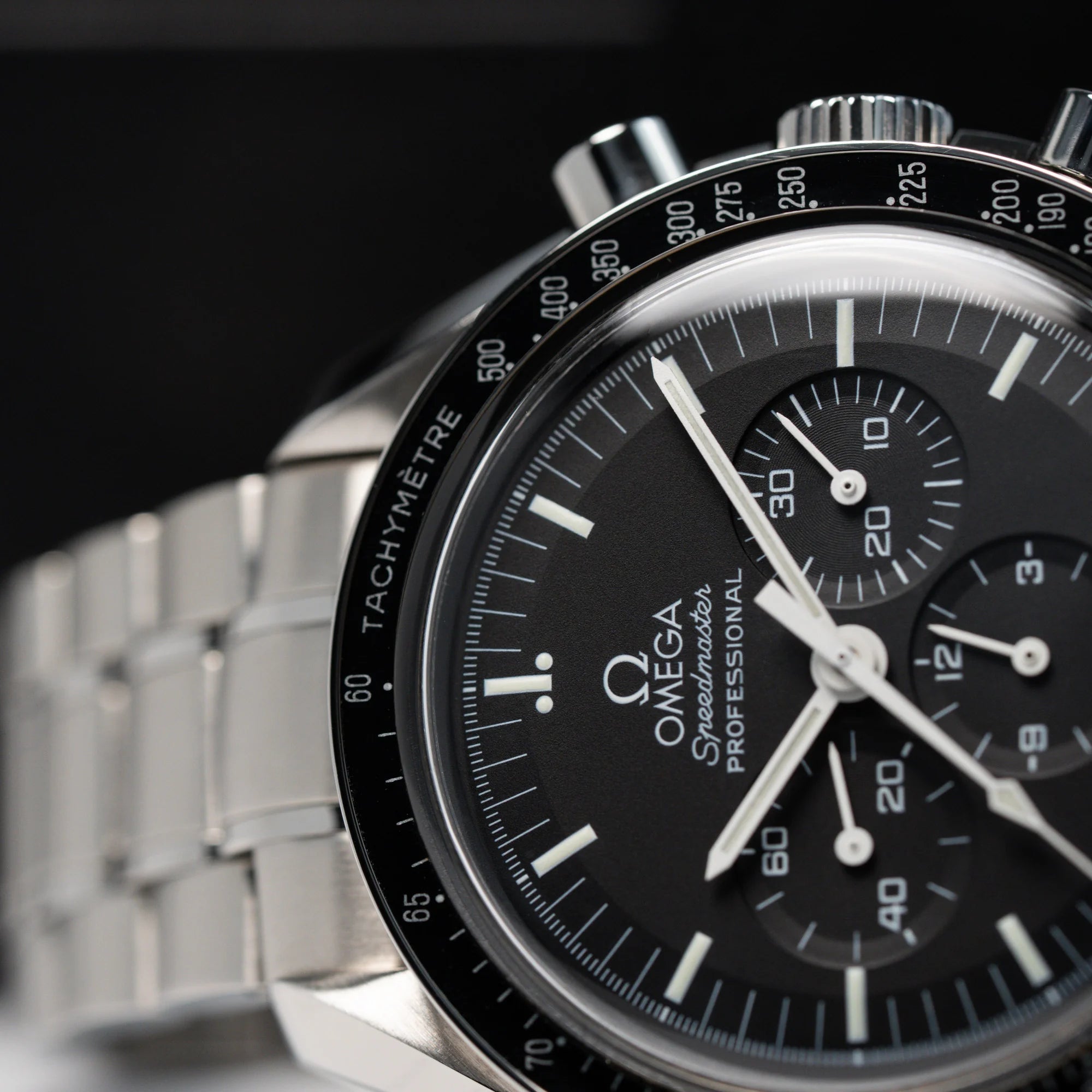 Detailaufnahme des klassischen schwarzen Zifferblatts der Omega Speedmaster Moonwatch Professional mit der Referenz 357.50.00