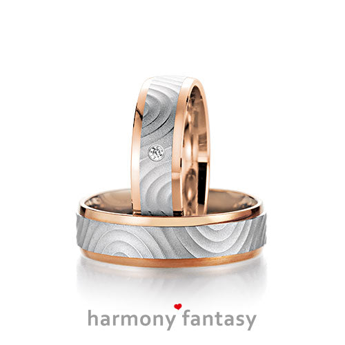 Produktfotografie des Trauringpaars Harmony Fantasy in Weißgold und Roségold, mit einem Diamant im Damenring