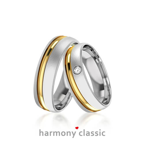 Produktfotografie des Trauringpaars Harmony Classic in Weißgold mit einem goldenen Streifen, mit Diamant im Damenring