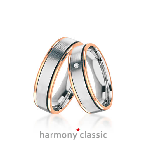 Produktfotografie des Trauringpaars Harmony Classic in Weißgold mit zwei  roségoldenen Streifen, mit Diamant im Damenring