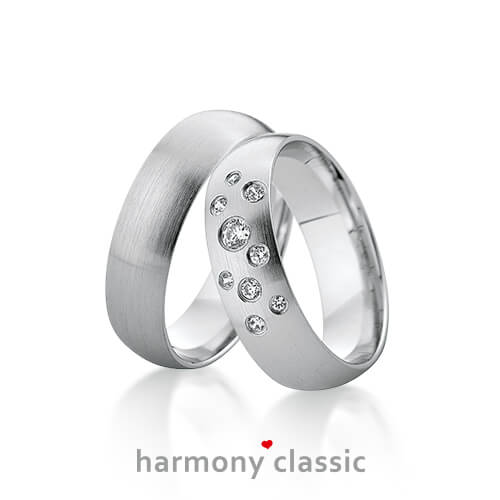Produktfotografie des Trauringpaars Harmony Classic in Weißgold, mit mehreren Diamanten im Damenring