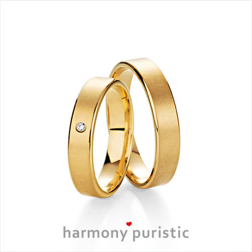 Produktfotografie des Trauringpaars Harmony Puristic in Gelbgold, mit einem Diamant im Damenring