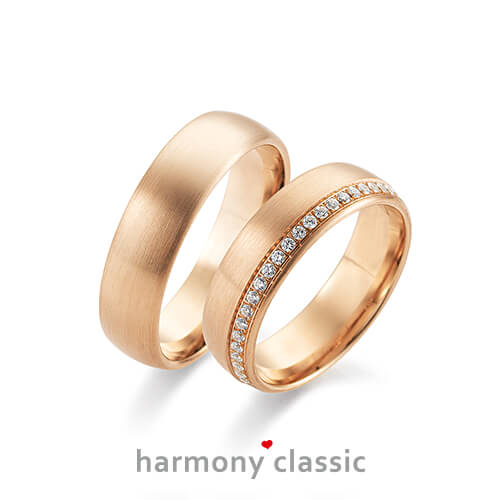 Produktfotografie des Trauringpaars Harmony Classic in Rosègold mit einem Diamantkranz im Damenring