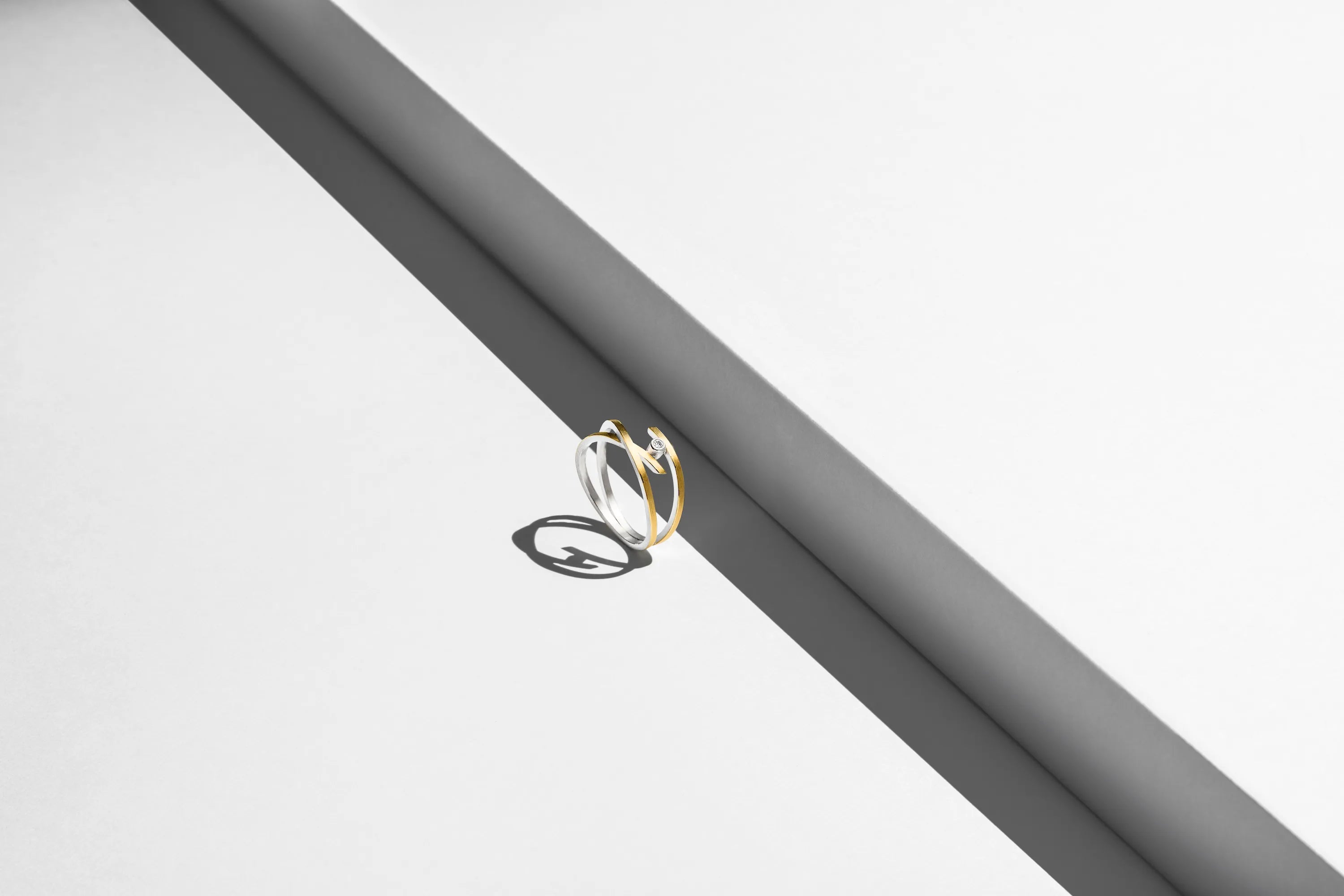Produktfotografie eines Manu Rings aus Silber mit Goldauflage und einem Brillanten, gefasst in einer ausgefallenen Ringschiene