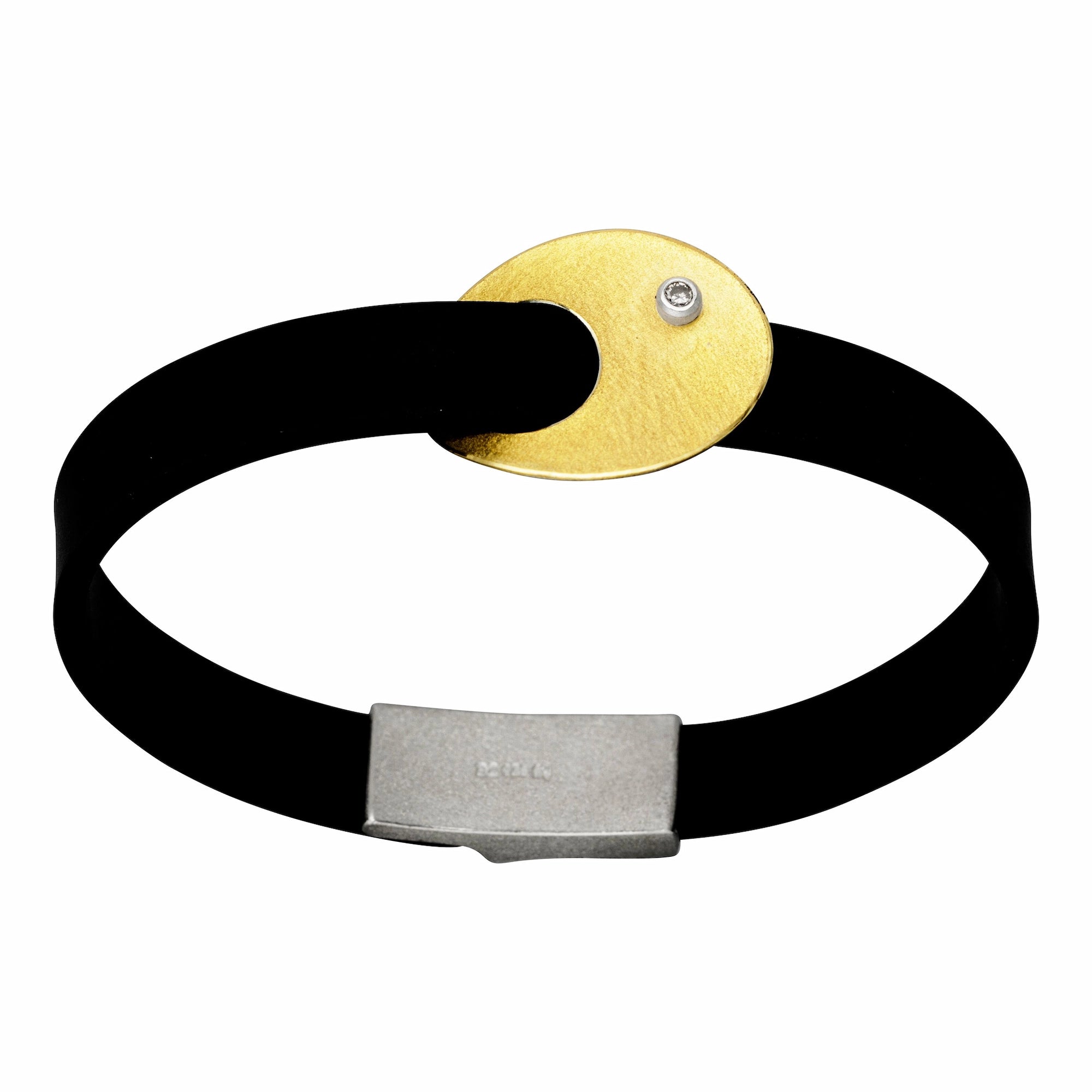Produktfotografie des Manu Armbands mit Goldauflage und Brillanten an einem schwarzem Naturkautschukband 