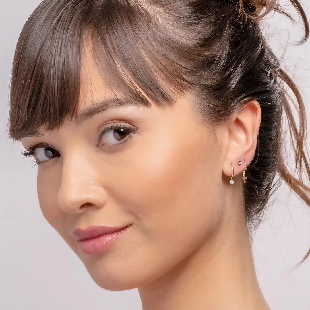 Frau trägt die die gelbgoldenen Flying-Diamond Ohrringe in ihrem Ohr trägt