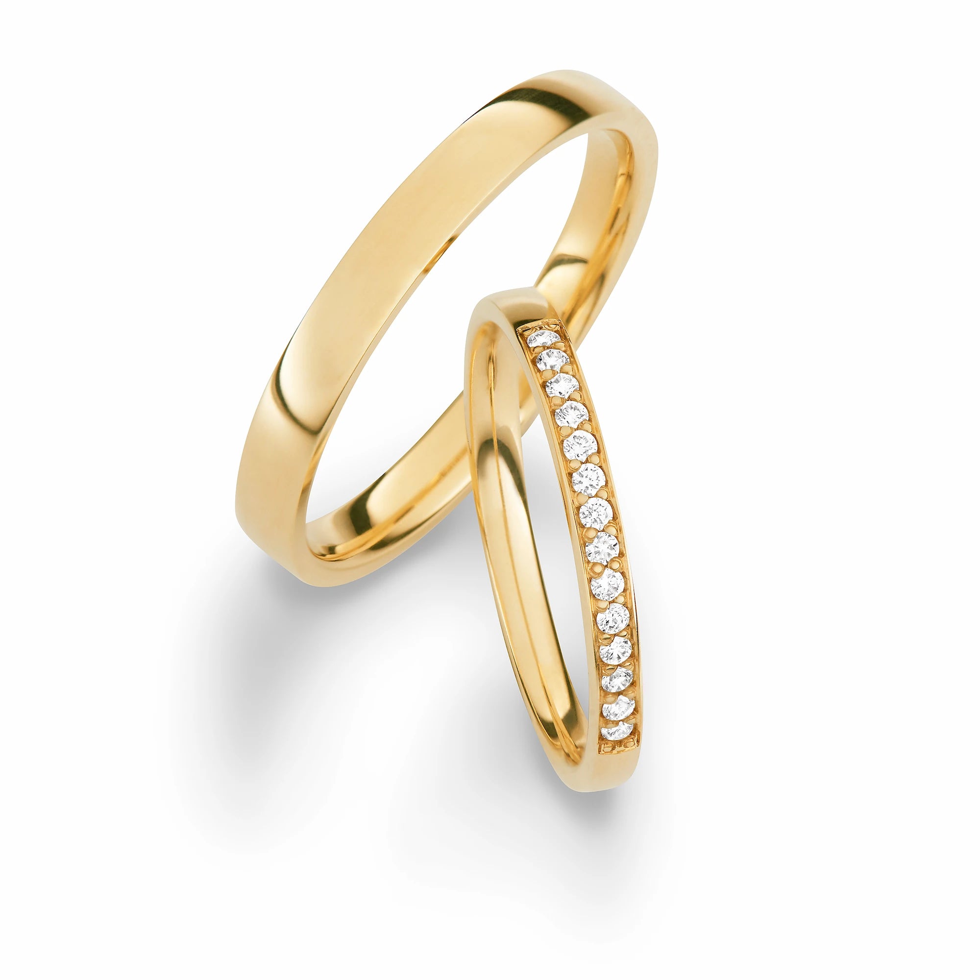 Produktfotografie des gelbgoldenen Max Kemper Trauringpaars mit einer feinen Oberflächenstruktur und einer Diamant-Reihe im Memoire-Stil im Damenring