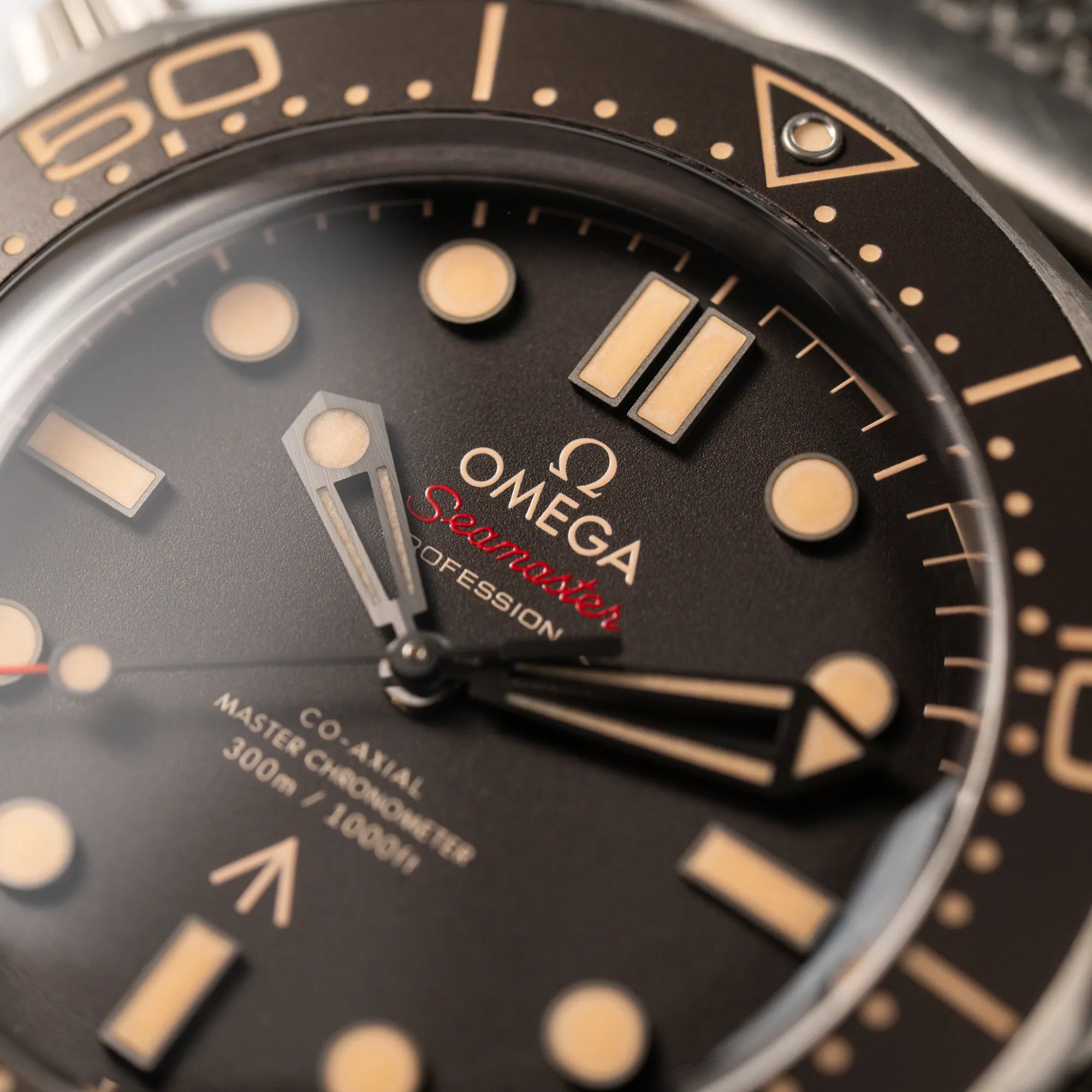 Makroaufnahme der Omega Seamaster 300m Diver No Time To Die Limited Edition aus Titan mit braunem Zifferblatt mit Fokus auf dem "Omega Seamsater Professional" Schriftzug