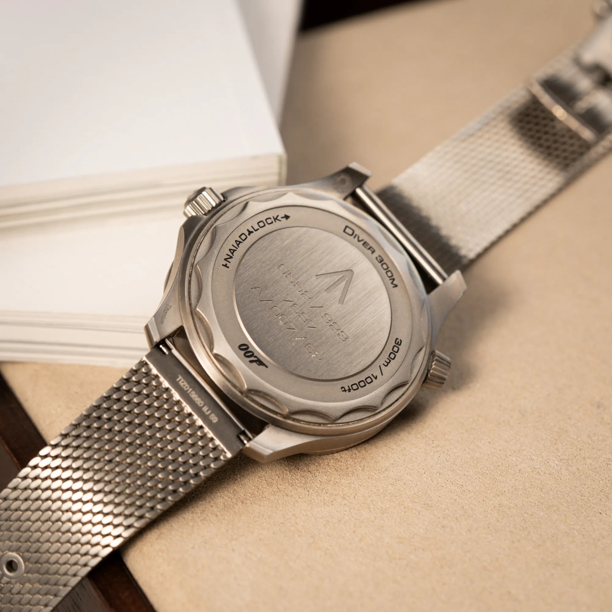 Produktfotografie der Omega Seamaster 300m Diver No Time To Die Limited Edition aus Titan mit braunem Zifferblatt zeigt den Gehäuseboden