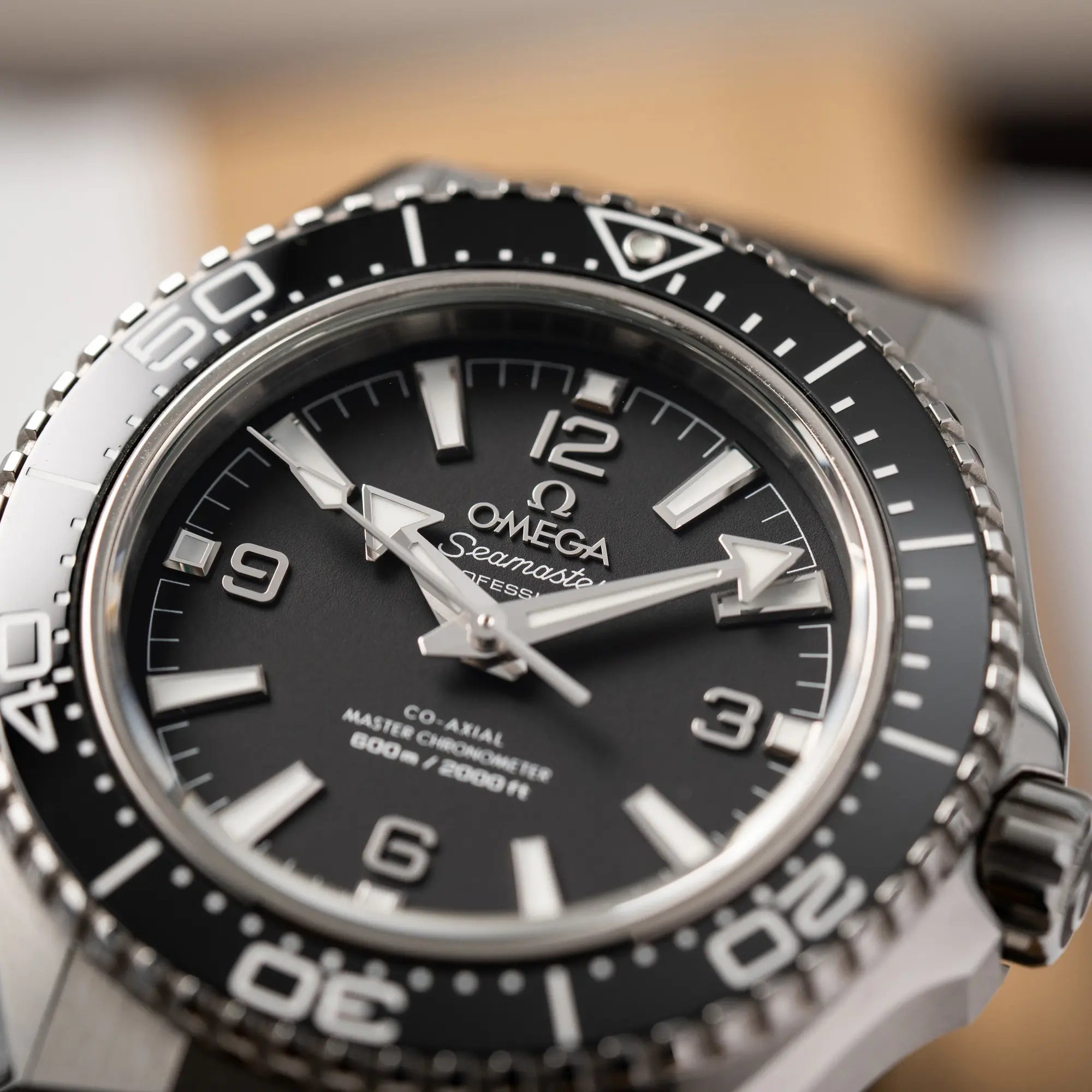 Detailaufnahme des Zeigersatzes auf dem schwarz matten Zifferblatt der Omega Seamaster Planet Ocean der Referenz 217.32.42.21.01.001 (4. Generation) mit schwarzem Zifferblatt und Lünette am schwarzen Kautschuk-Armband
