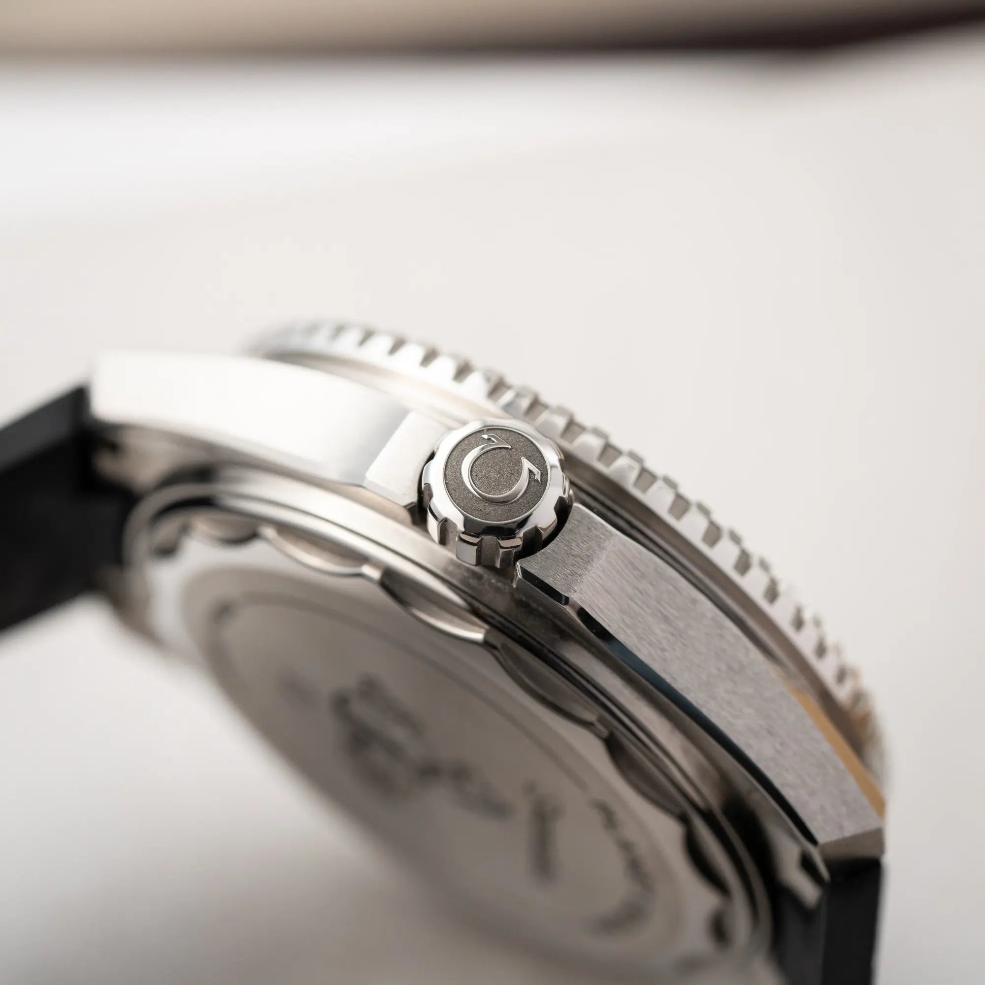 Detailaufnahme der Aufzugskrone der Omega Seamaster Planet Ocean der Referenz 217.32.42.21.01.001 (4. Generation) mit schwarzem Zifferblatt und Lünette am schwarzen Kautschuk-Armband