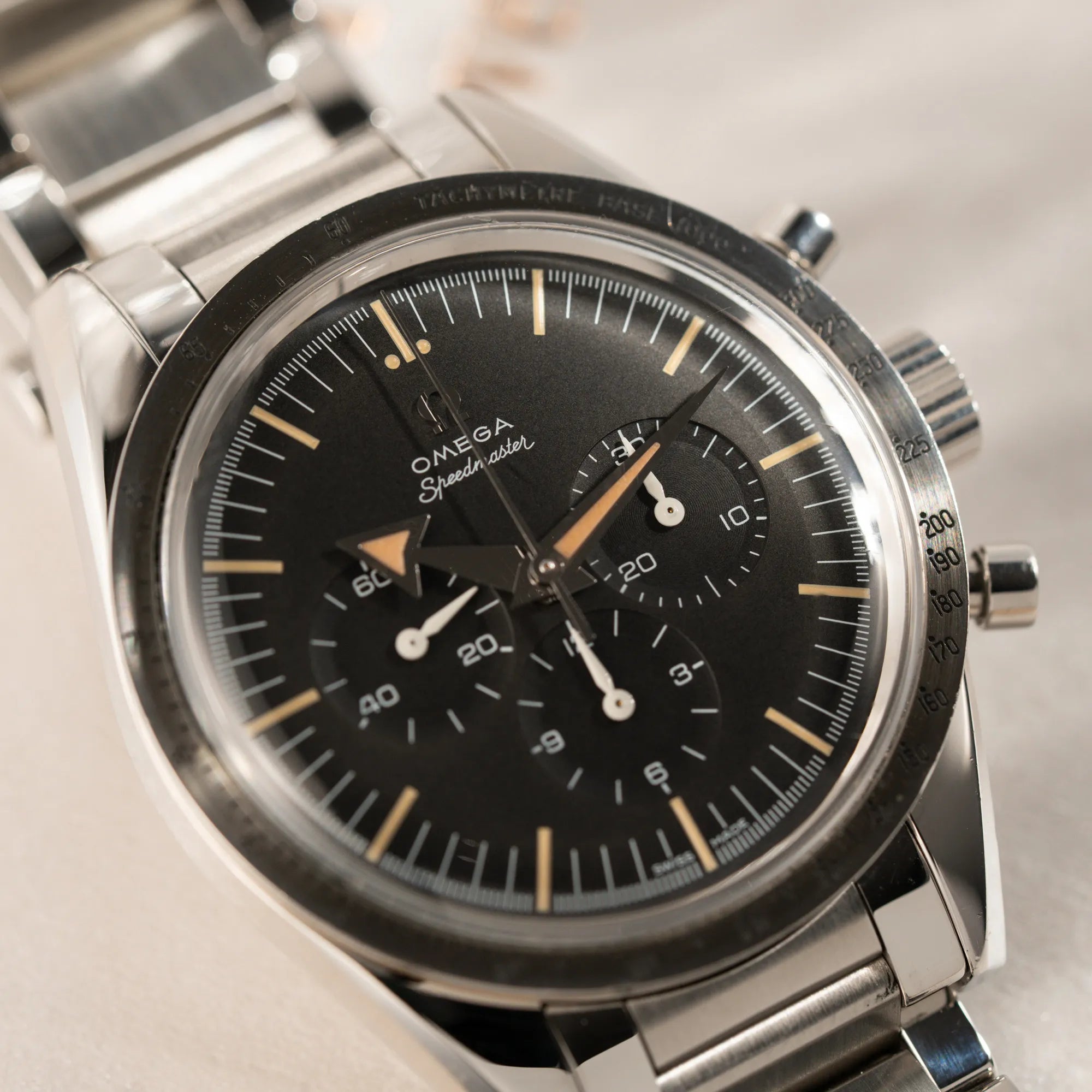 Nahaufnahme der Omega Speedmaster 1957 Trilogy Limited Edition mit einem anthrazitfarbenen Zifferblatt mit Vintage-Look und dem original Omega-Stahlband im Ed-White-Design