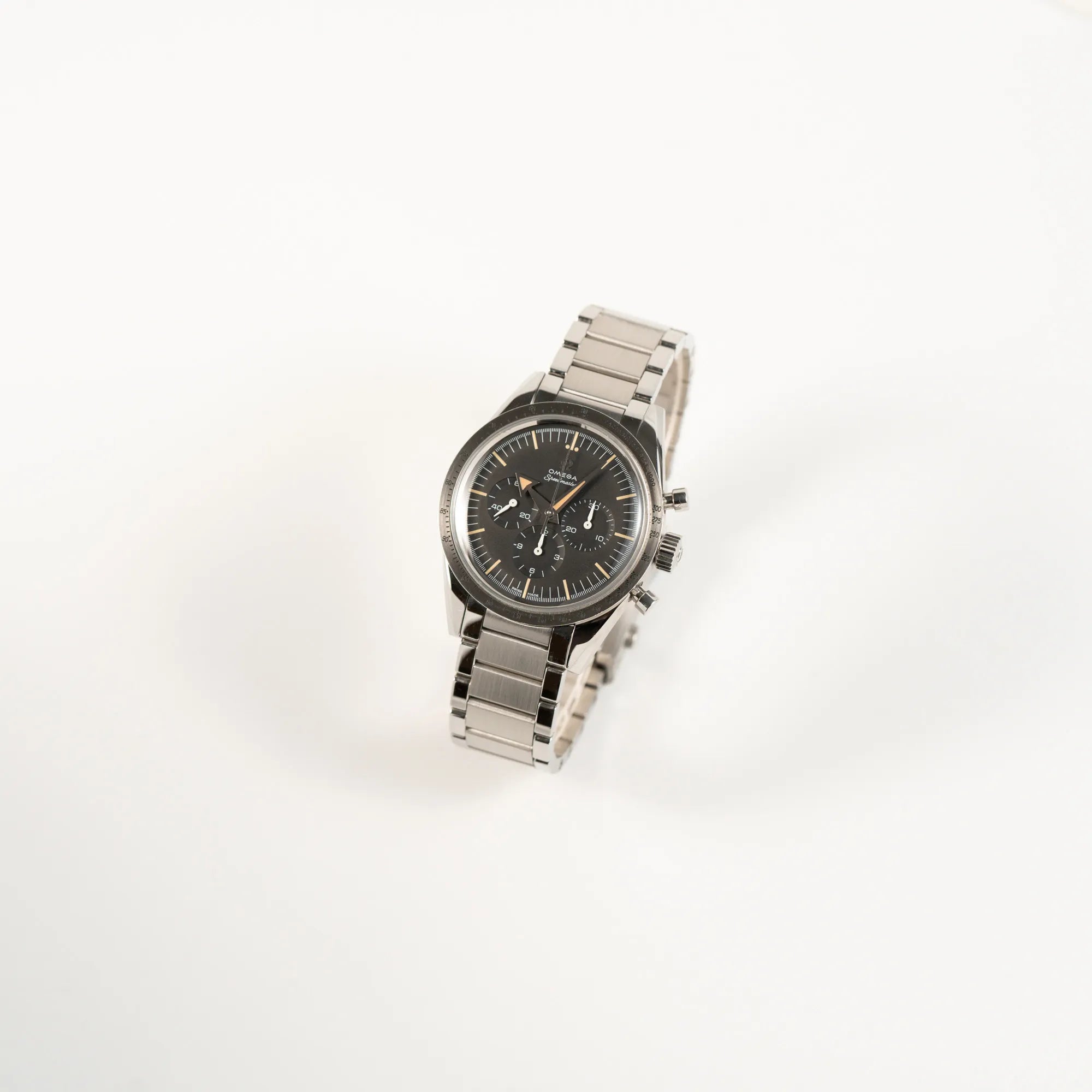 Leicht schräge Ansicht der Omega Speedmaster 1957 Trilogy Limited Edition mit einem anthrazitfarbenen Zifferblatt mit Vintage-Look und dem original Omega-Stahlband im Ed-White-Design