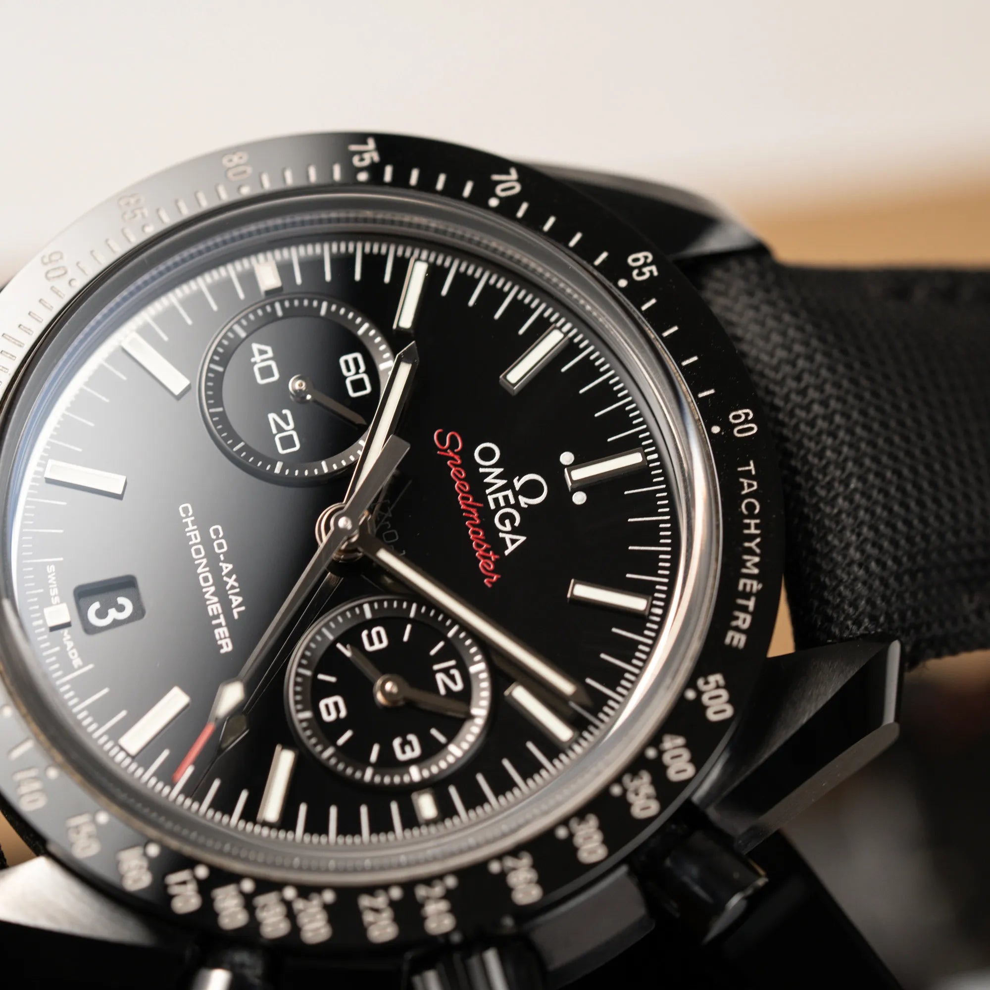 Detailaufnahme des Uhrenkopfes von dem Omega Speedmaster "Darkside of the Moon" Chronograph mit schwarzem Zifferblatt und aus schwarzer Keramik gefertigtem Gehäuse