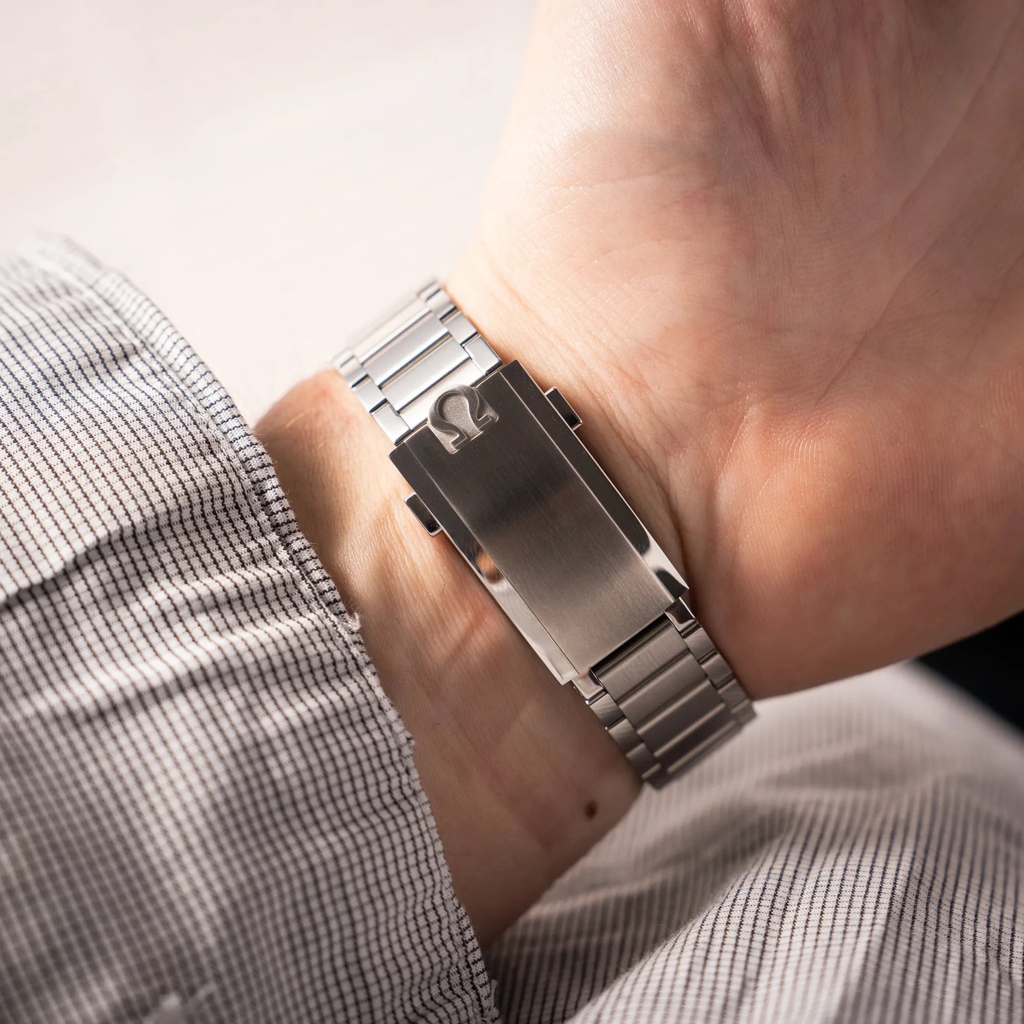 Wristshot mit der Omega Speedmaster FOIS der Referenz 310.30.40.50.06.001 mit dem dunkelblauen Zifferblatt mit dunkel-beigen Indizes im Vintage-Look und einem vom Standard-Modell abgeänderten Stahl-Armband, was beides an das klassische Speedy-Modell erinnert, zeigt die originale Faltschliesse