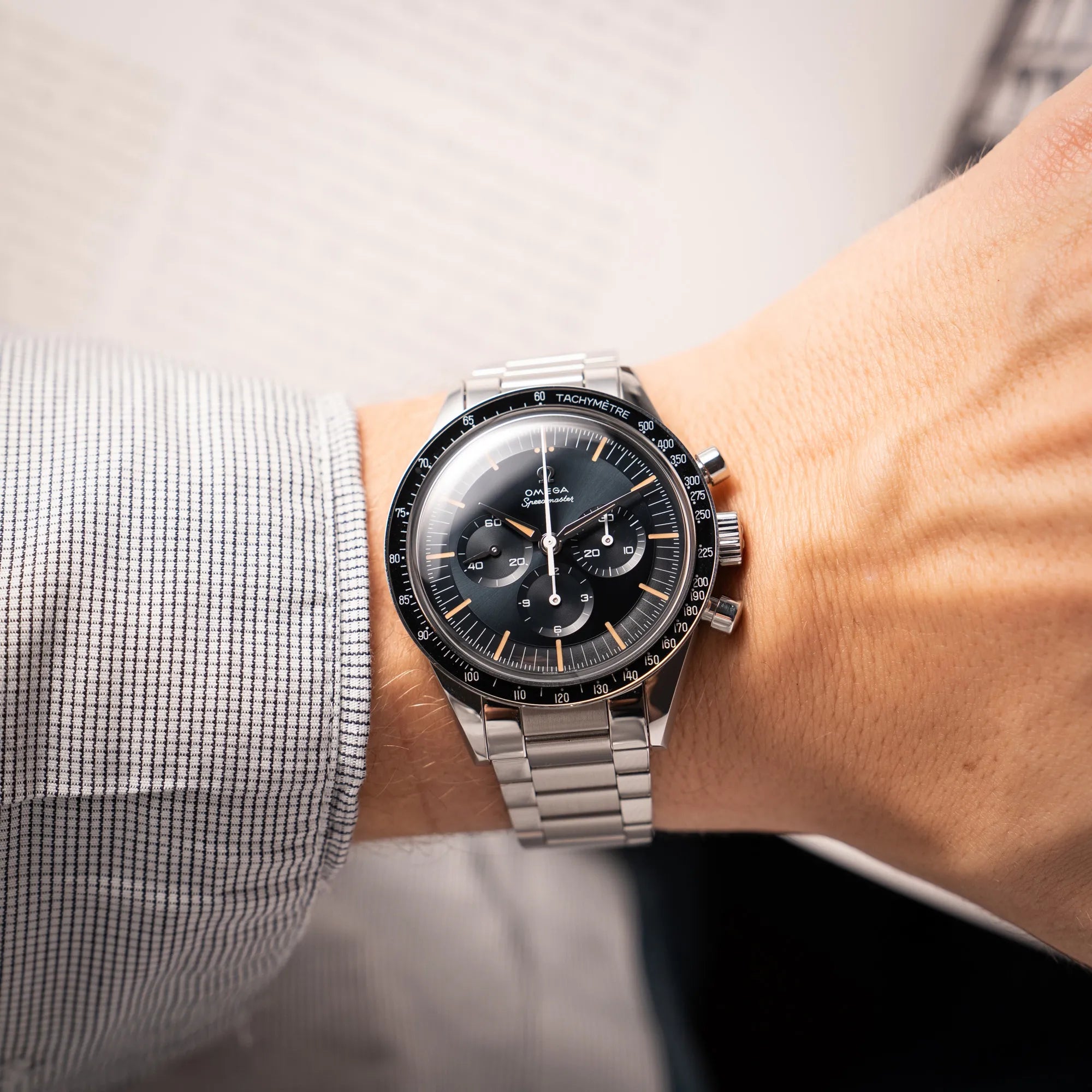 Wristshot mit der Omega Speedmaster FOIS der Referenz 310.30.40.50.06.001 mit dem dunkelblauen Zifferblatt mit dunkel-beigen Indizes im Vintage-Look und einem vom Standard-Modell abgeänderten Stahl-Armband, was beides an das klassische Speedy-Modell erinnert